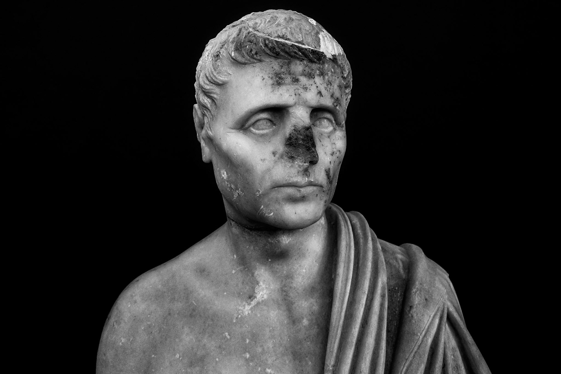 Delos, Greece - May 22nd 2018: A marble bust of a man in a toga, likely a Roman official or dignitary, stands as a testament to the island's rich history.