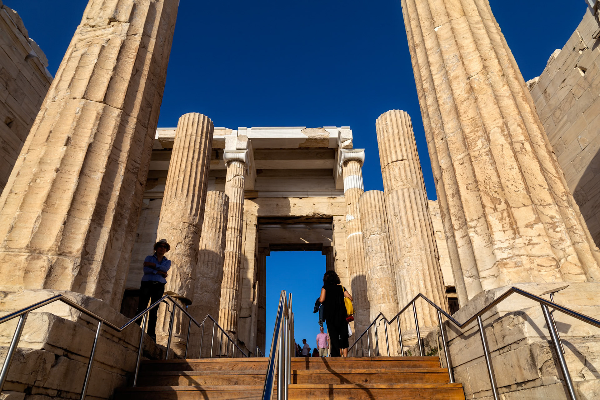 Acropolis, Athens, Greece - May 23rd 2018: Tourists ascend the Propylaea steps, the monumental gateway to the Acropolis, to explore the ancient site.