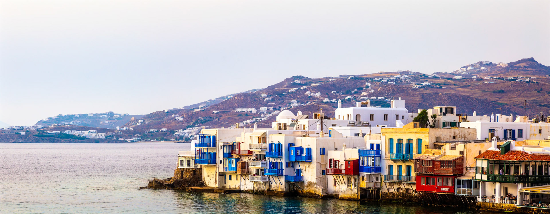 Mykonos, Greece - May 23rd 2018: Waterfront buildings in Little Venice, Mykonos, stand out with their colorful balconies and unique architecture.