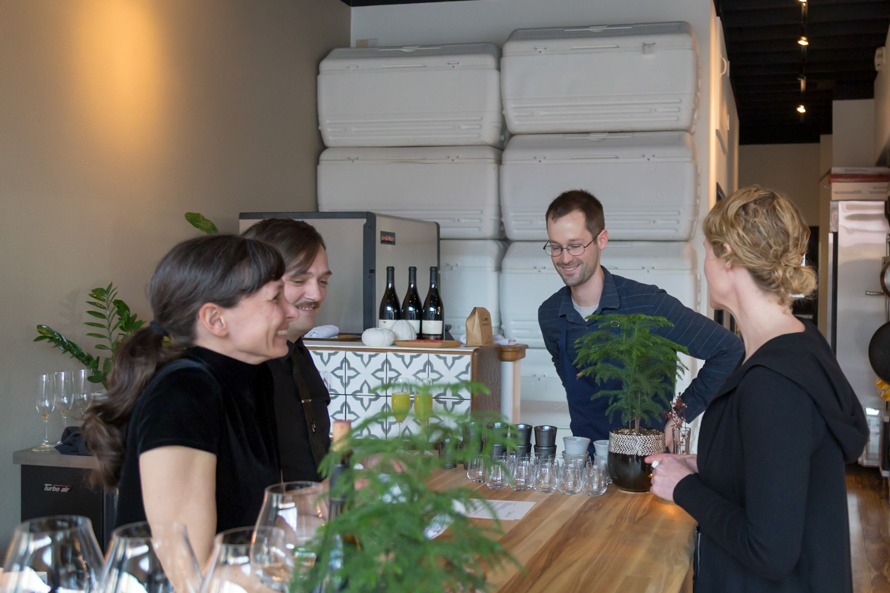 Fog Lark, Portland, Oregon - April 6th 2018: People are gathered at a bar, possibly for a wine tasting or social event, engaging in conversation.