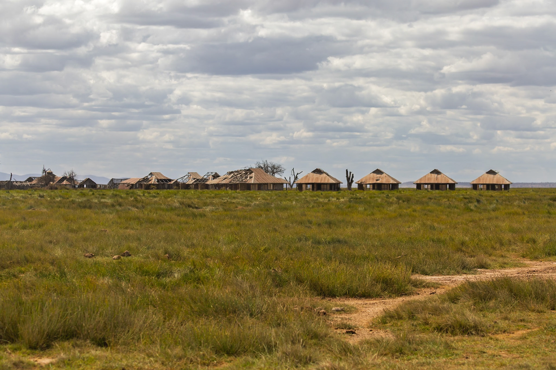 Dilapidated buildings stand in Amboseli National Park, Kenya, a reminder of past habitation or structures awaiting restoration.