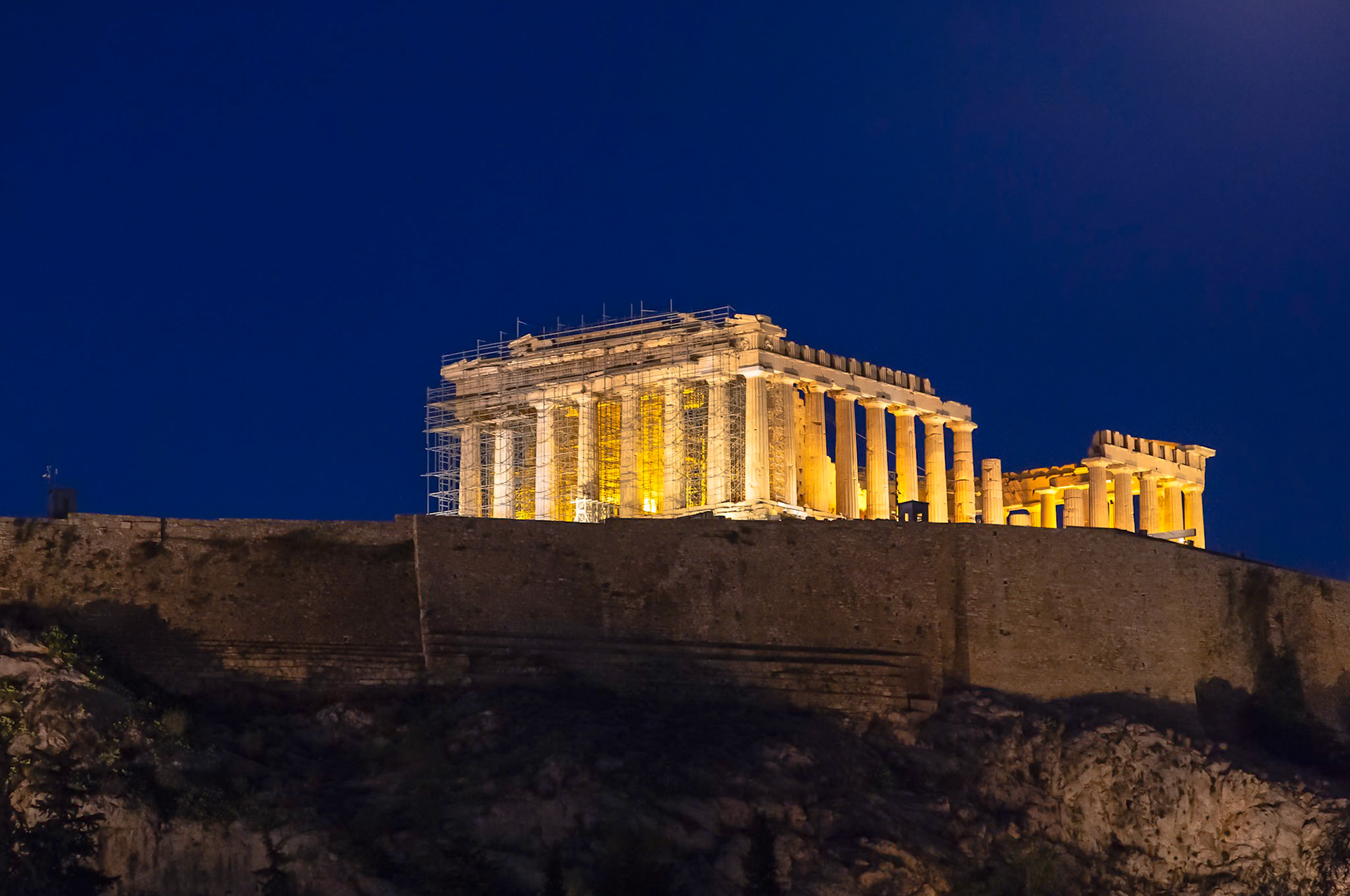 Acropolis, Athens, Greece - May 23rd 2018: The Parthenon is illuminated at night, undergoing restoration to preserve this ancient temple.
