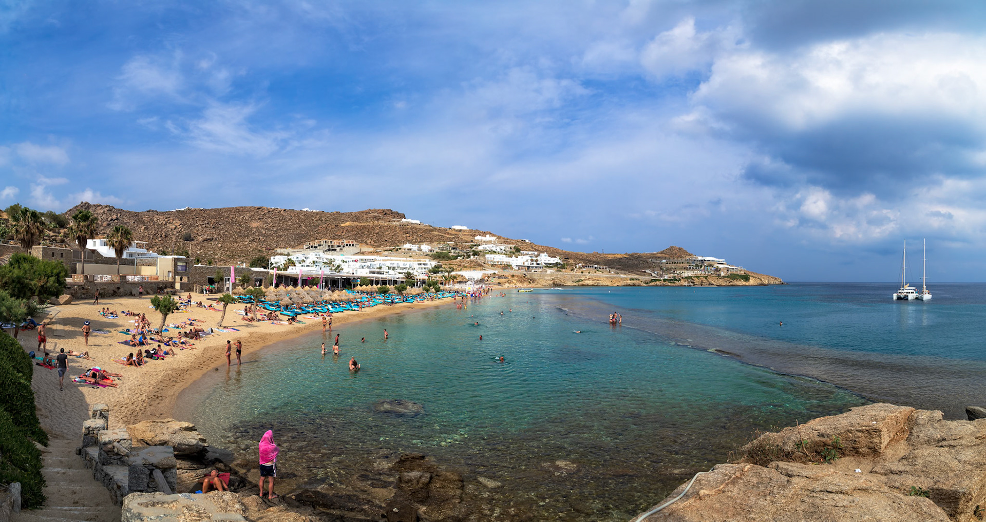 Paradise Beach, Mykonos, Greece - May 24th 2018: People enjoy swimming and sunbathing on a sunny day at Paradise Beach, Mykonos.