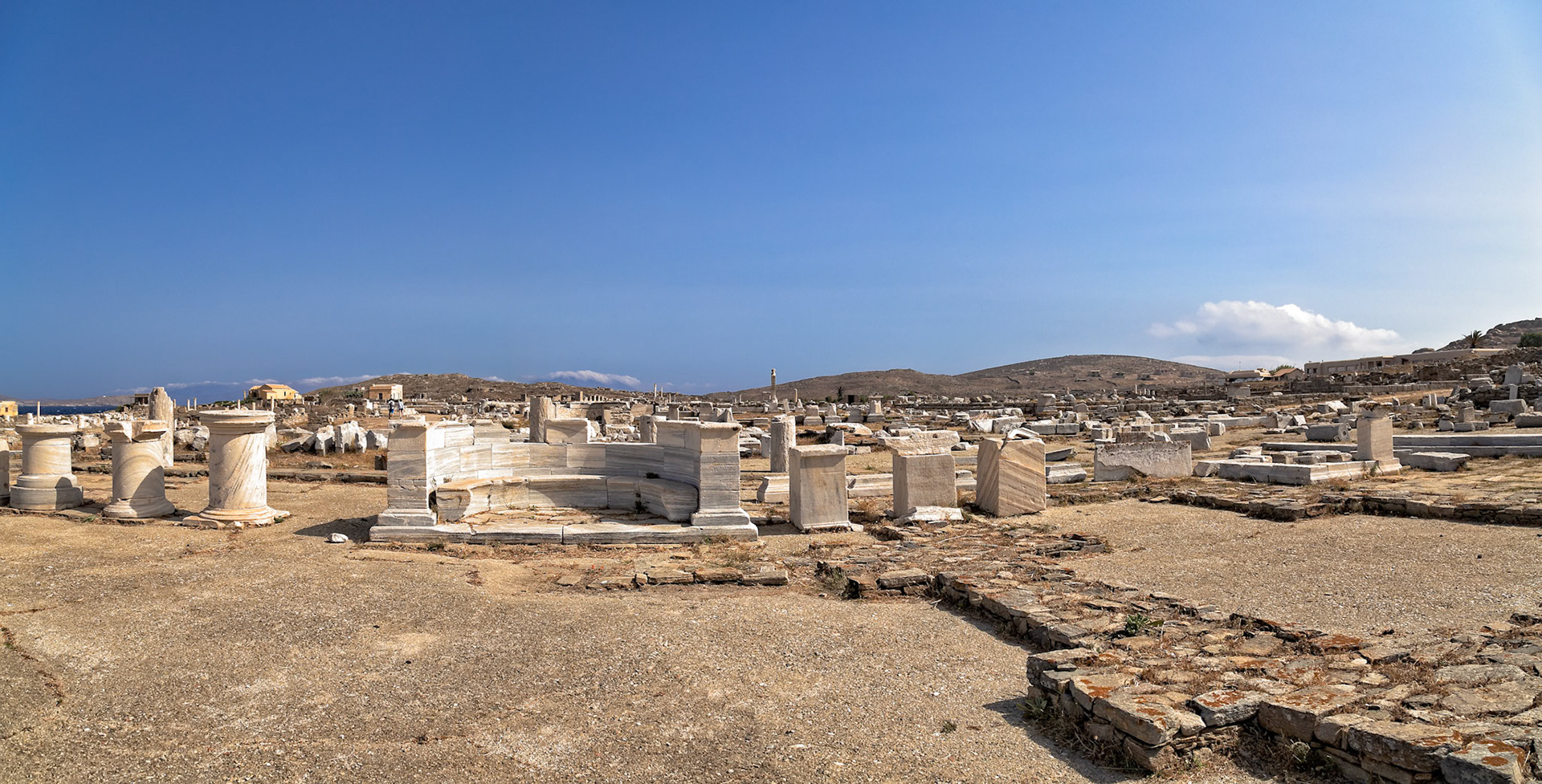 Delos, Greece - May 22nd 2018: Ruins of ancient structures stand under a clear sky. These are remnants of a once-thriving civilization on the island.