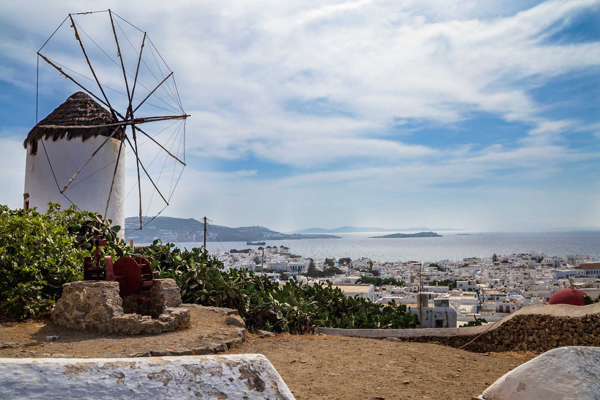 Mykonos, Greece - May 22nd 2018: A windmill stands overlooking the town, a reminder of the island's history and a popular tourist attraction.