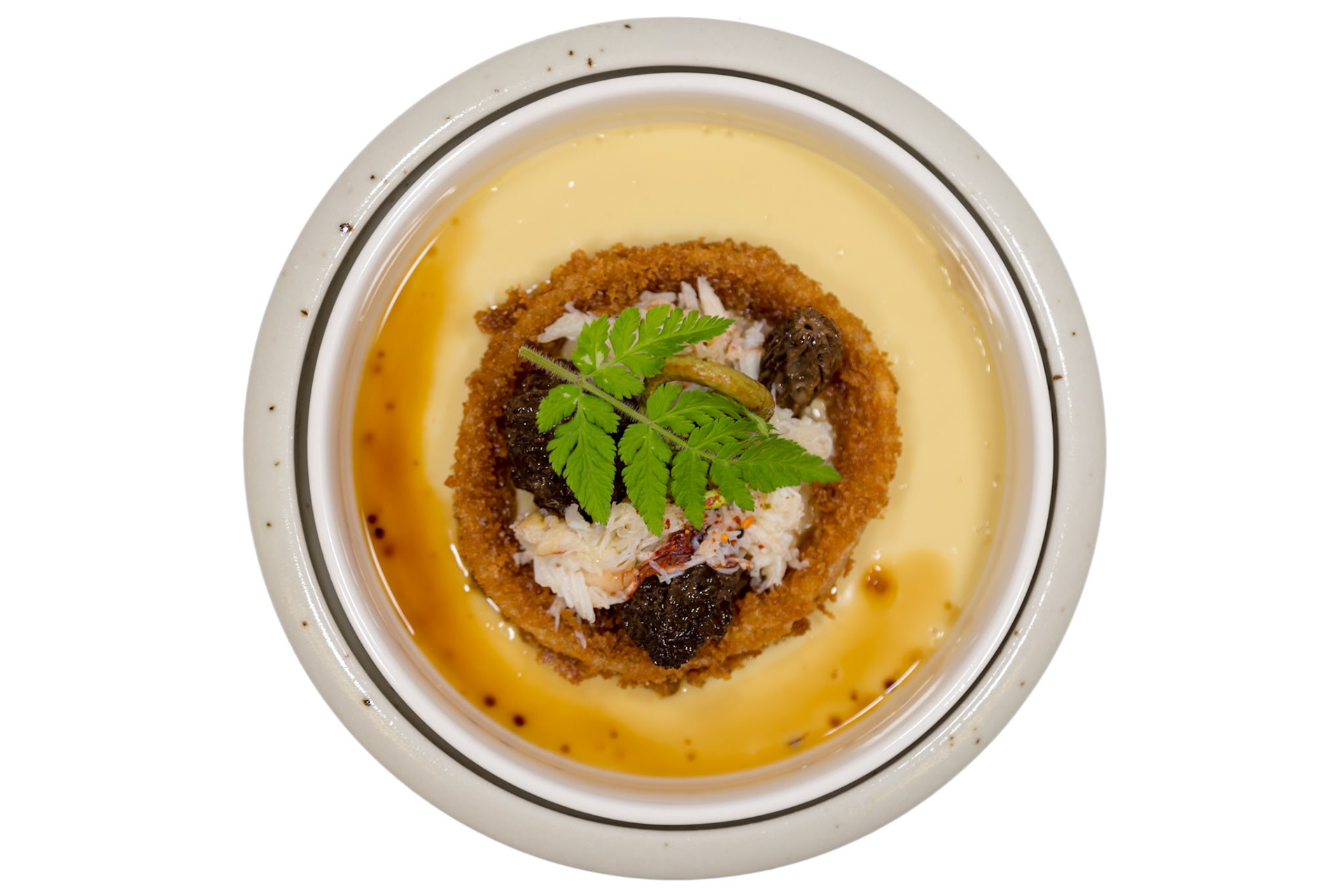 Fog Lark, Portland, Oregon - April 6th 2018: A chef presents a savory custard dish with crab, morels, and a crispy garnish for a unique dining experience.