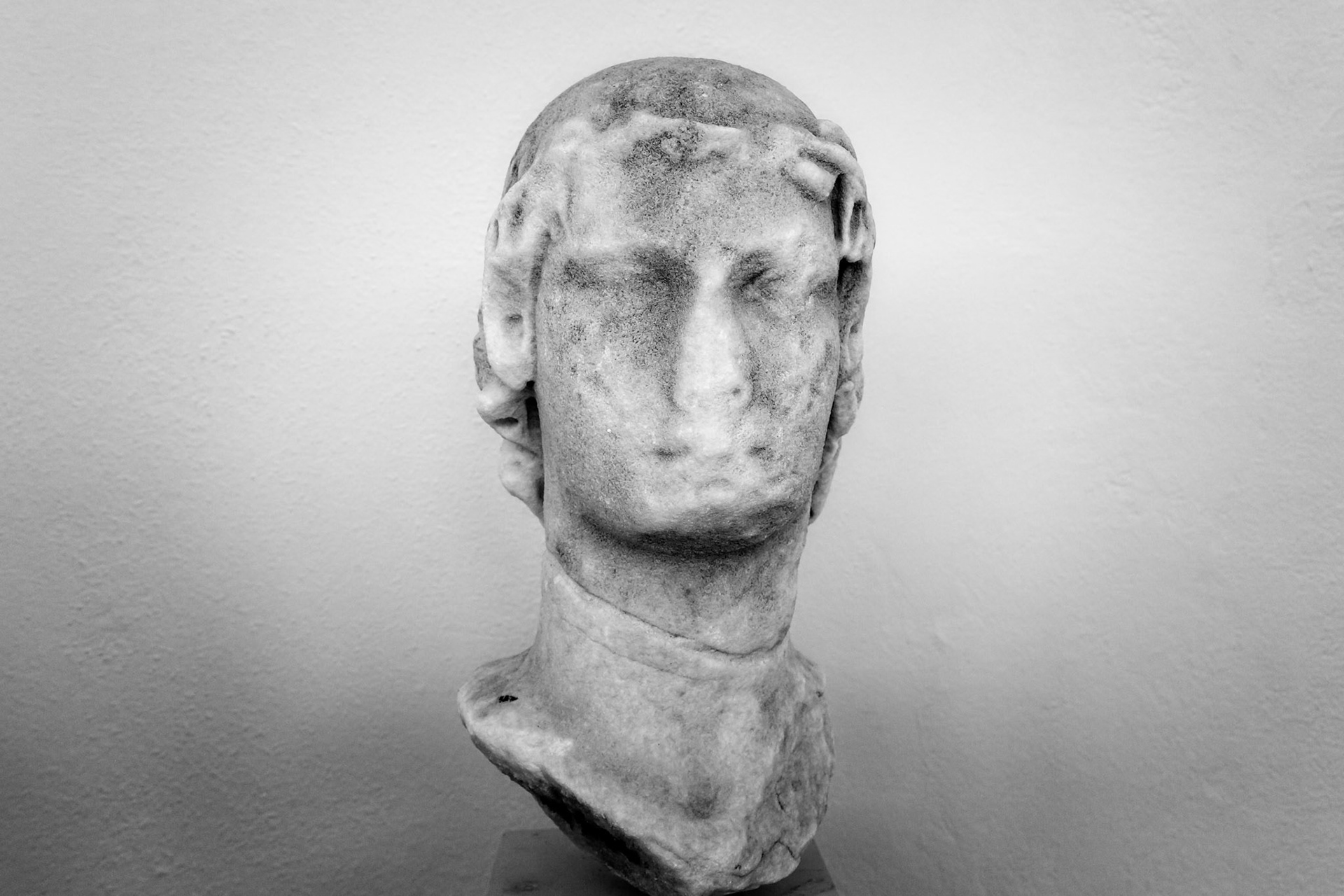 Delos, Greece - May 22nd 2018: A marble bust of a man with curly hair sits on display, showcasing ancient Greek artistry and historical significance.