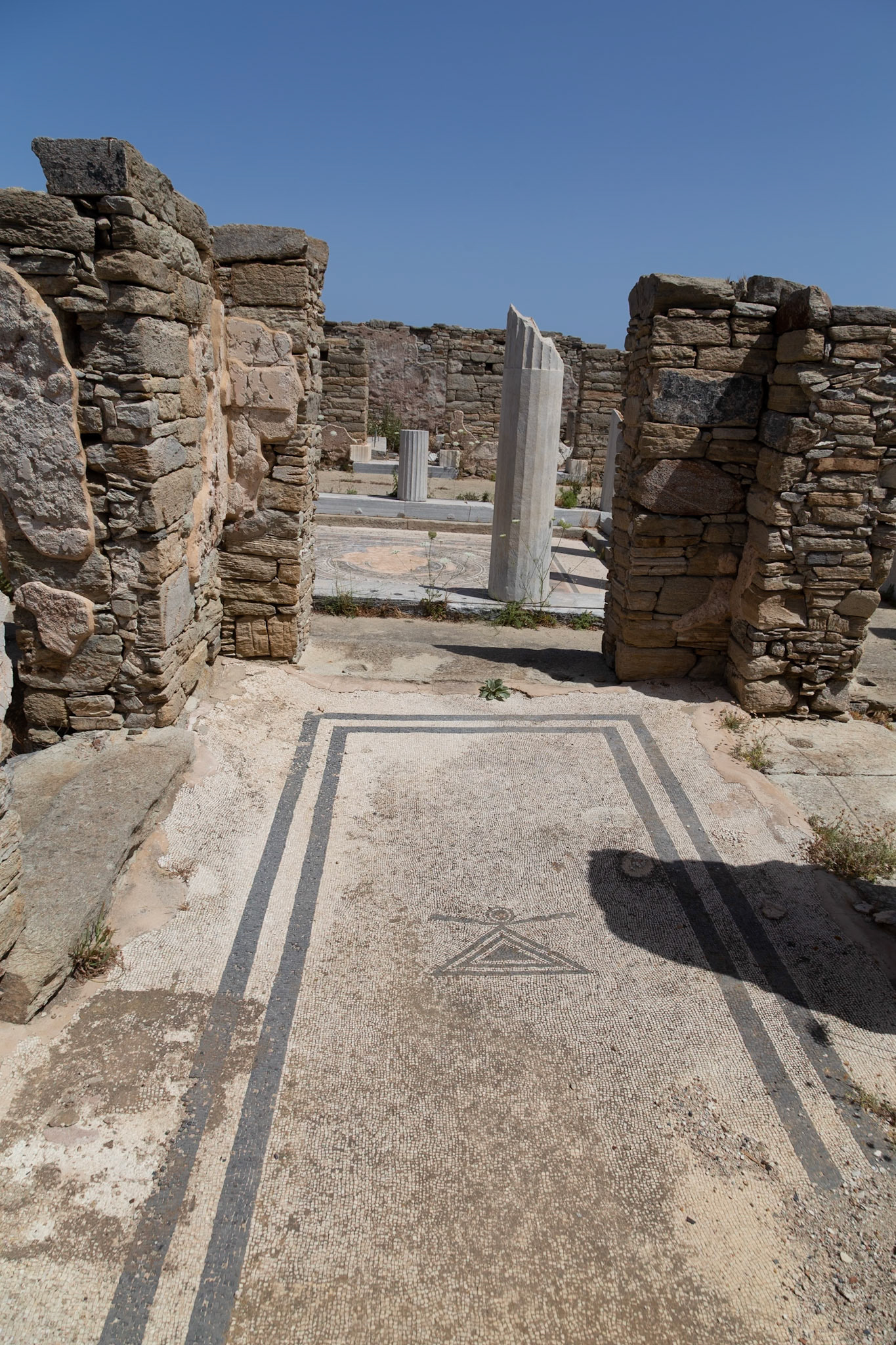 Delos, Greece - May 22nd 2018: A mosaic floor with a triangle design is seen in the ruins of Delos. The mosaic is part of an ancient building, showcasing the art of the time.