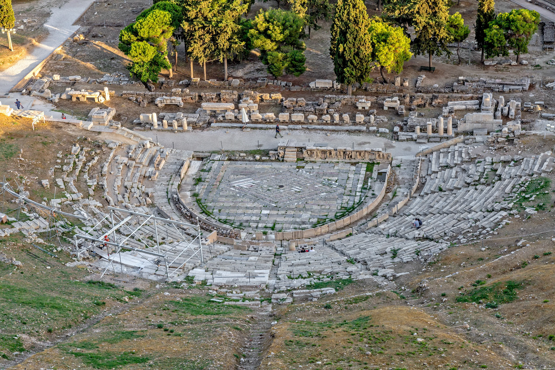 Acropolis, Athens, Greece - May 23rd 2018: The ancient Theatre of Dionysus is being restored, with workers on scaffolding, while tourists explore the site.