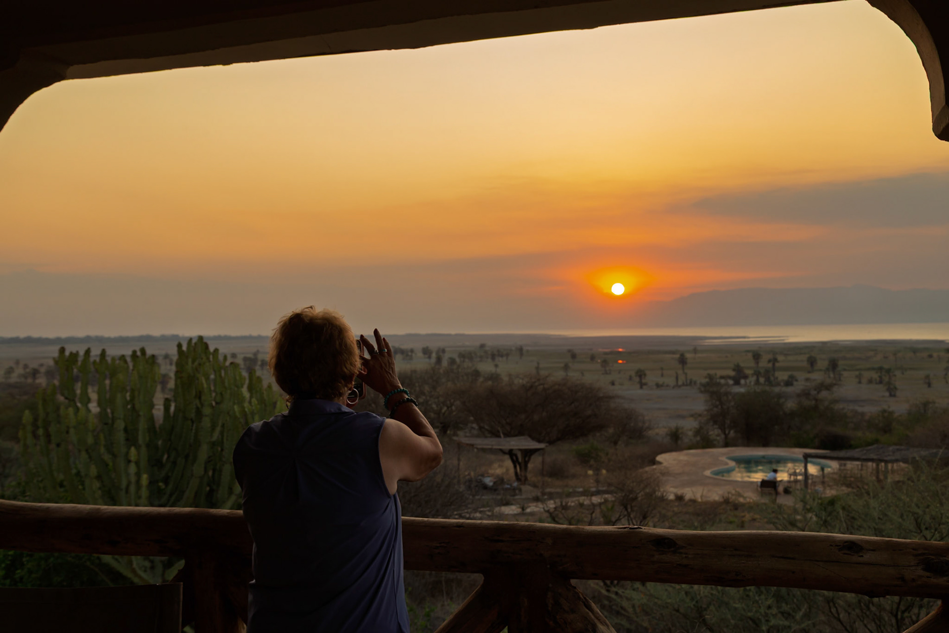 Lake Eyasi, Tanzania - September 27th 2025: A tourist photographs a stunning sunset over the African savanna.