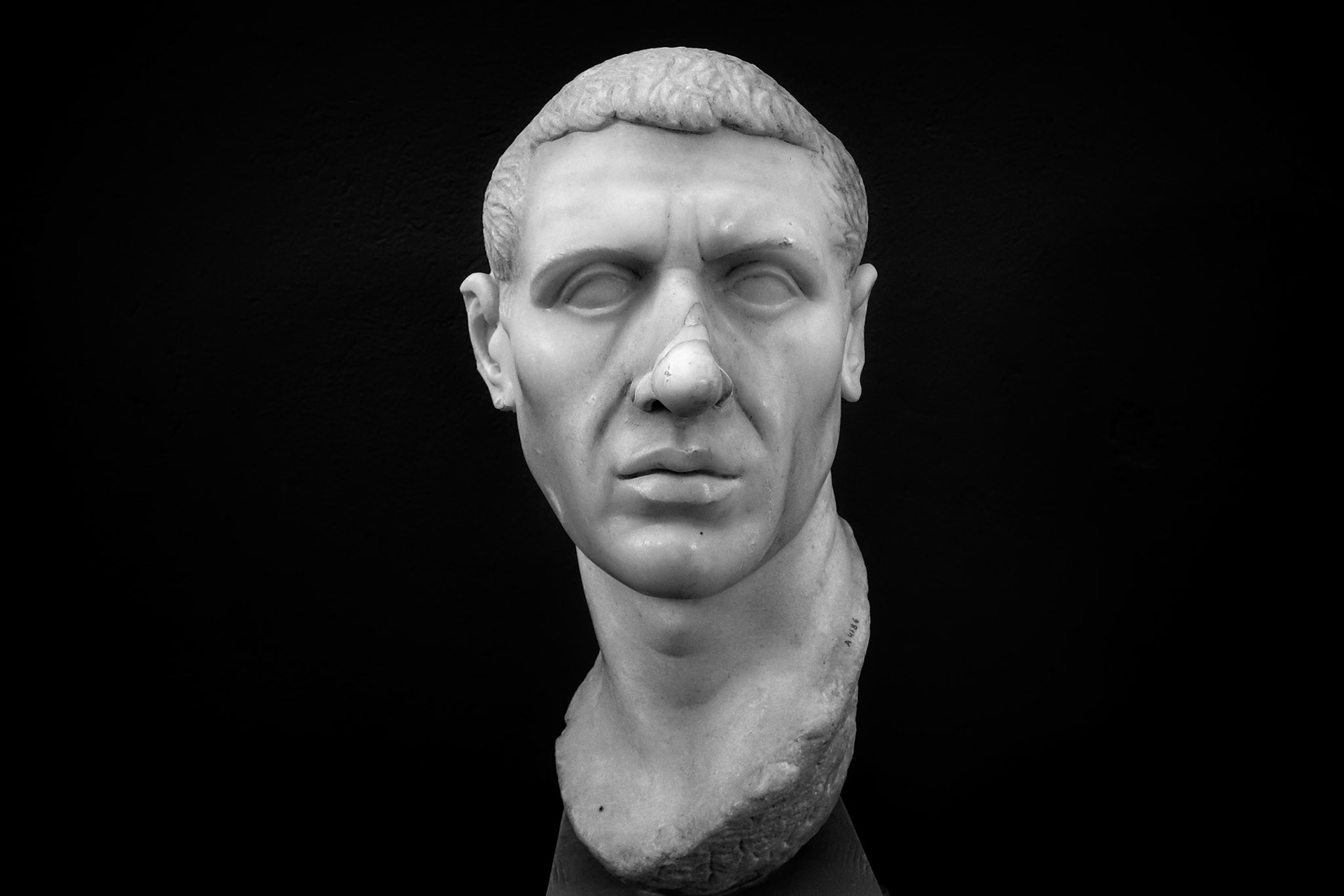 Delos, Greece - May 22nd 2018: A marble bust of a man, possibly a Roman official, is on display. The bust is eyeless, with damage to the nose and neck.