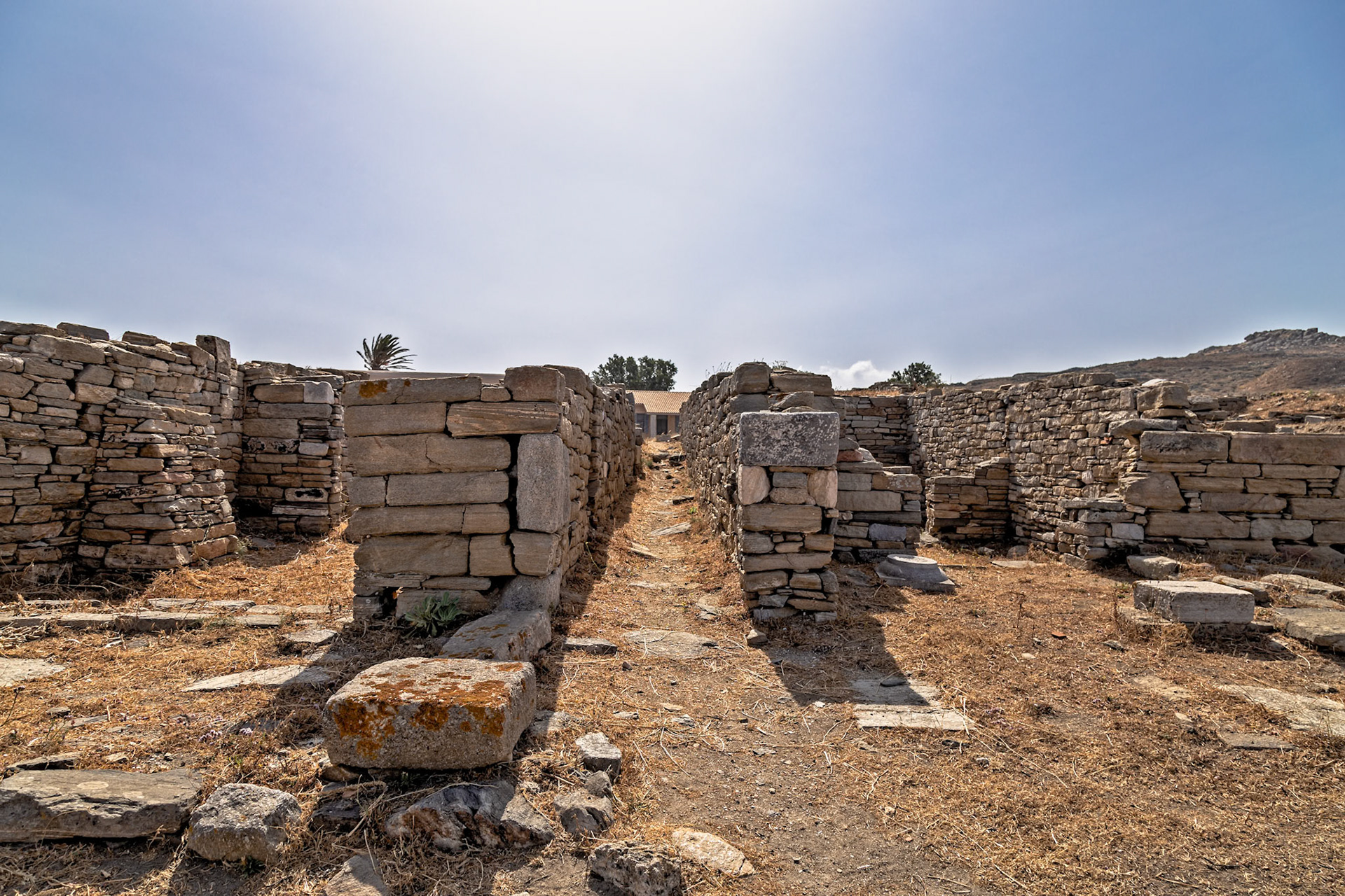 Delos, Greece - May 22nd 2018: Ruins of ancient stone structures stand under a clear sky, showcasing the historical architecture of Delos.