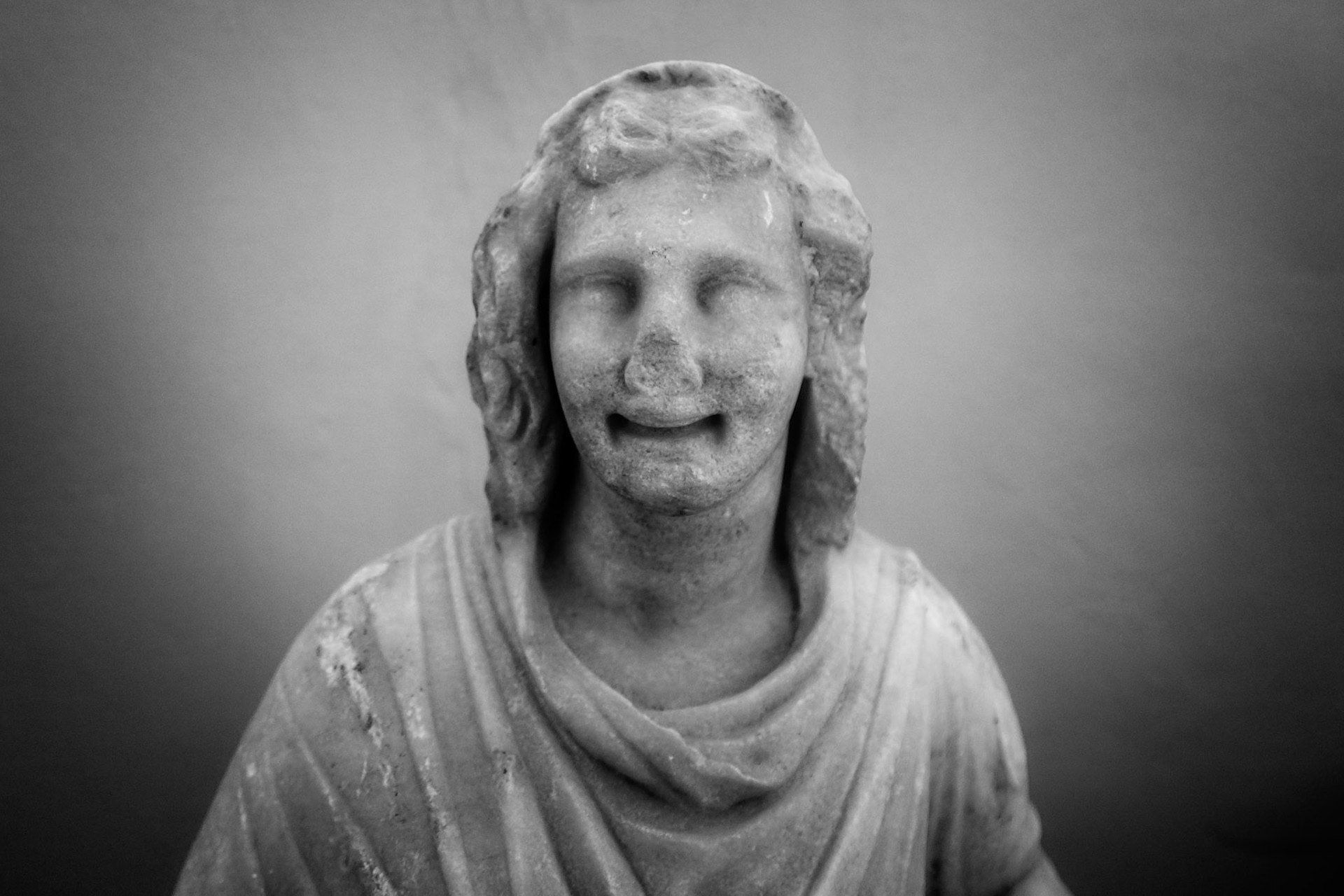 Delos, Greece - May 22nd 2018: A monochrome shot of a weathered statue, possibly a deity or important figure, displayed at the archeological site.