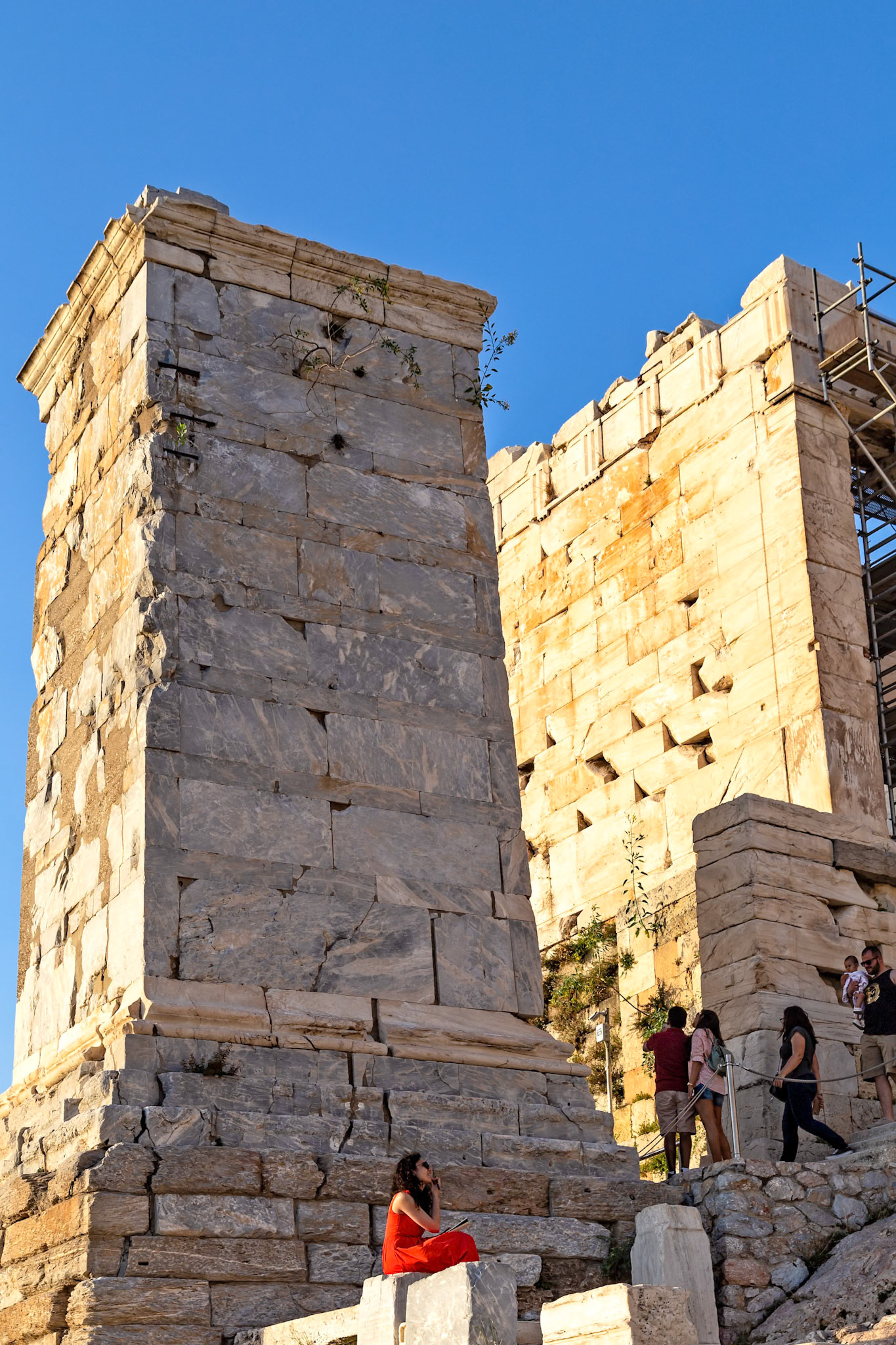 Acropolis, Athens, Greece - May 23rd 2018: Tourists explore the Propylaea, the monumental gateway to the Acropolis, a UNESCO World Heritage Site.