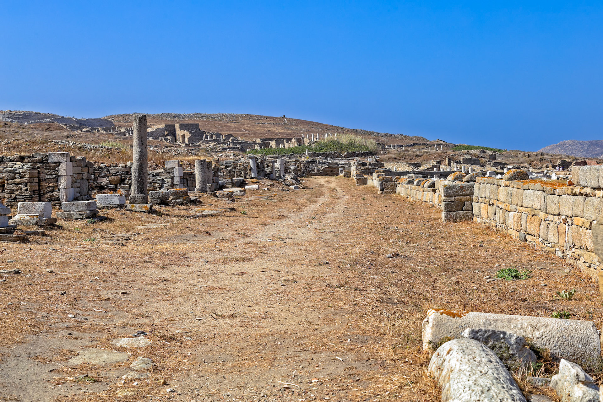Delos, Greece - May 22nd 2018: Ruins of ancient buildings and columns stand on Delos, a Greek island and archaeological site, showcasing its rich history and cultural significance.