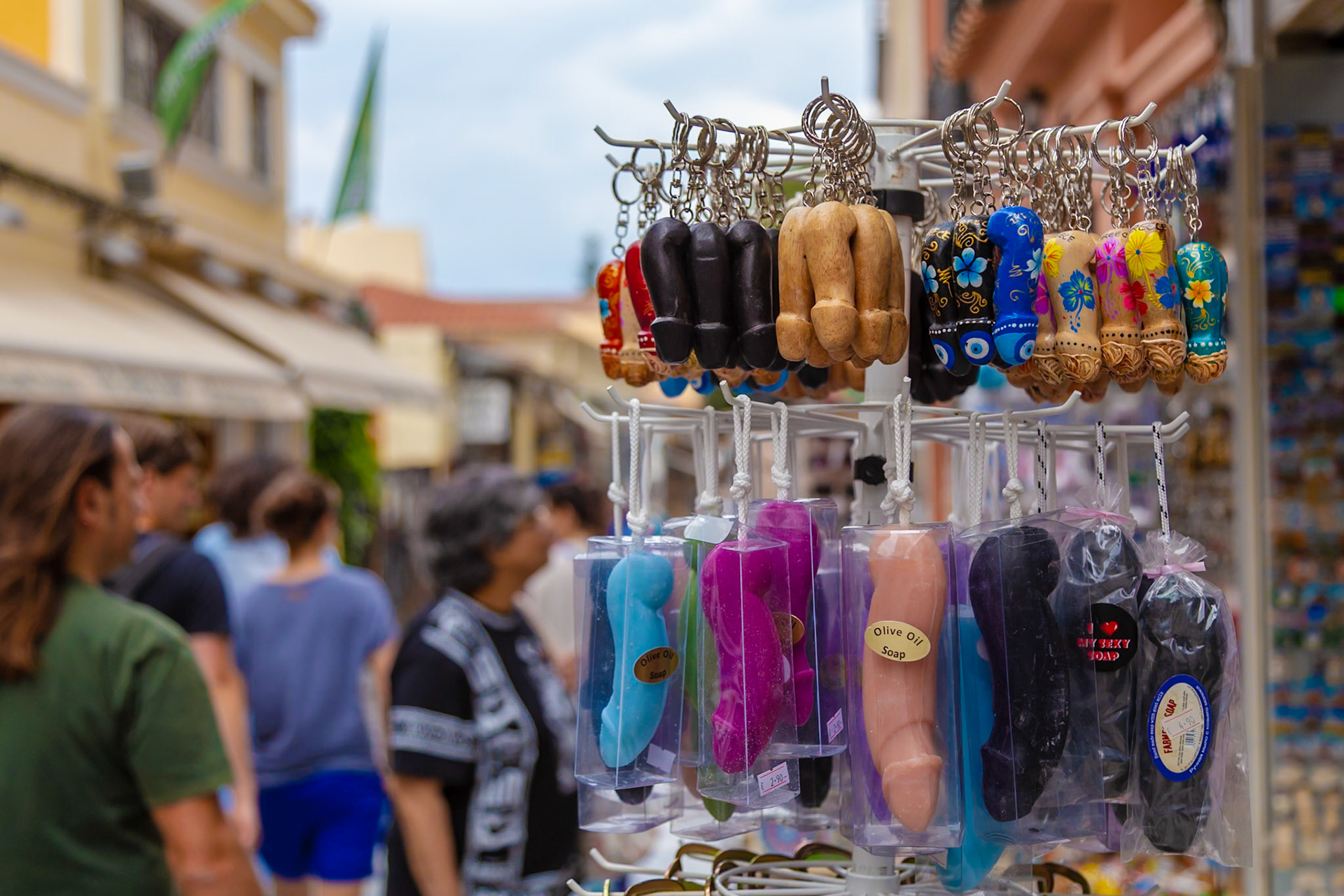 Athens, Greece - May 23rd 2018: Tourists browse a souvenir shop selling phallic-shaped keychains and olive oil soaps, a popular novelty item in Greece.