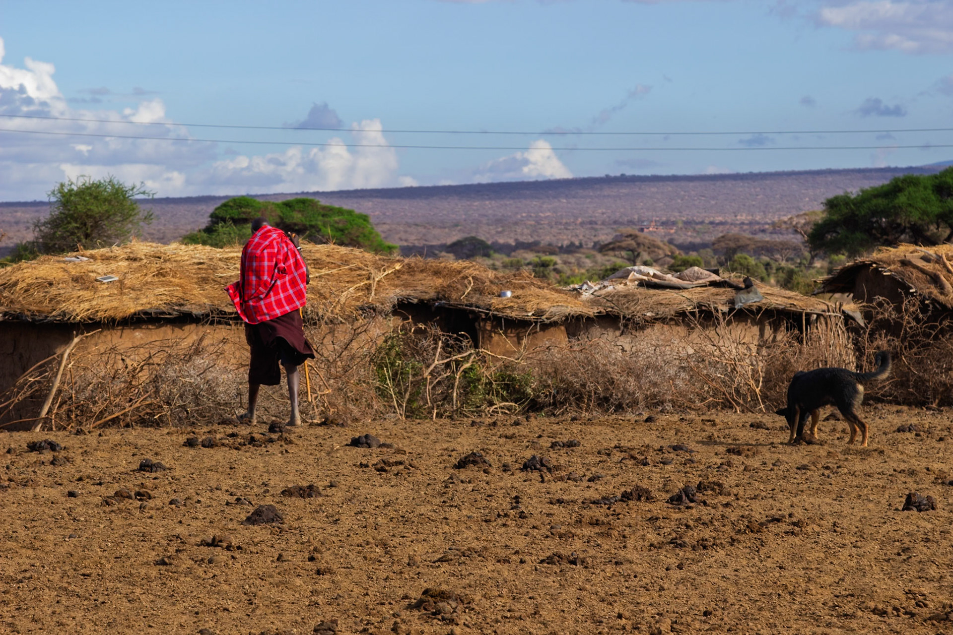 A Maasai man walks with his dog near his home in the Kilima Region, Kenya.