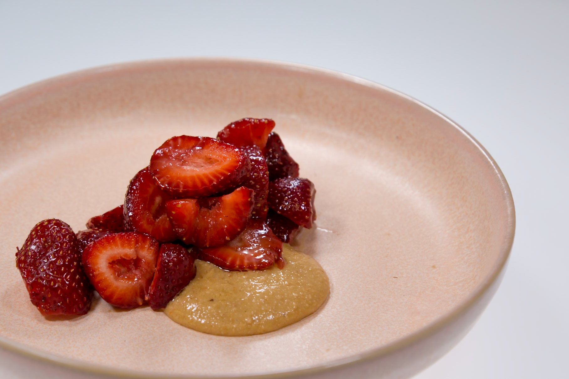 Fog Lark, Portland, Oregon - April 6th 2018: A chef plates a dessert of glazed strawberries with a smear of sauce for a tasting menu.