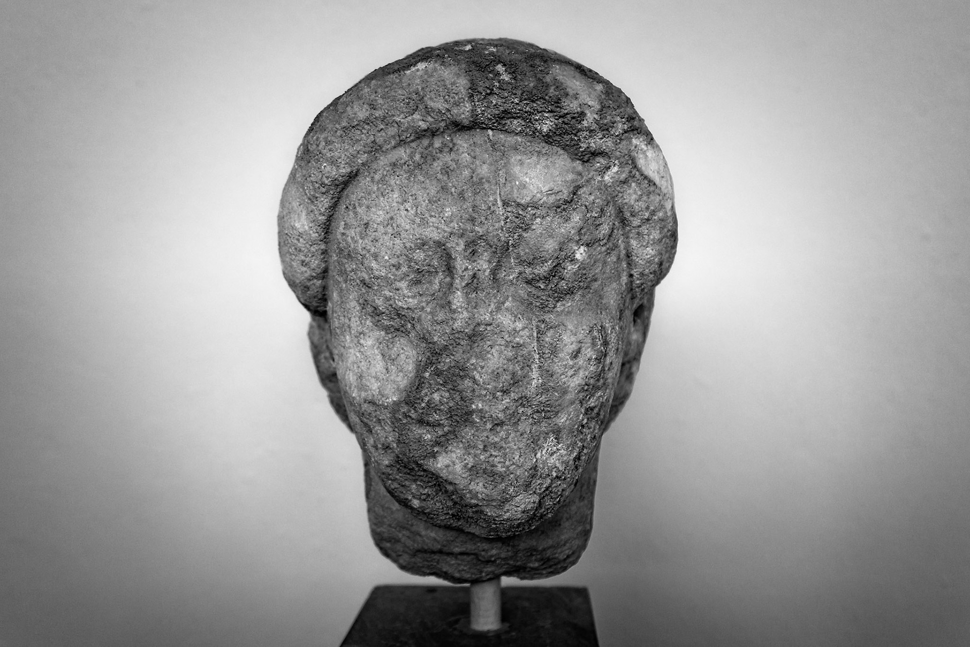 Delos, Greece - May 22nd 2018: A weathered, ancient stone head sculpture is displayed, showcasing the artistry and history of Delos.
