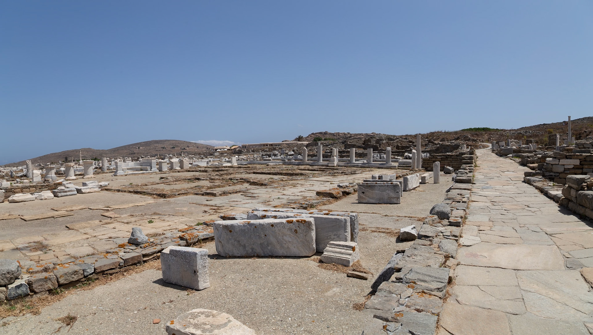 Delos, Greece - May 22nd 2018: Ruins of ancient structures stand under a clear sky. The site showcases the historical significance of Delos.
