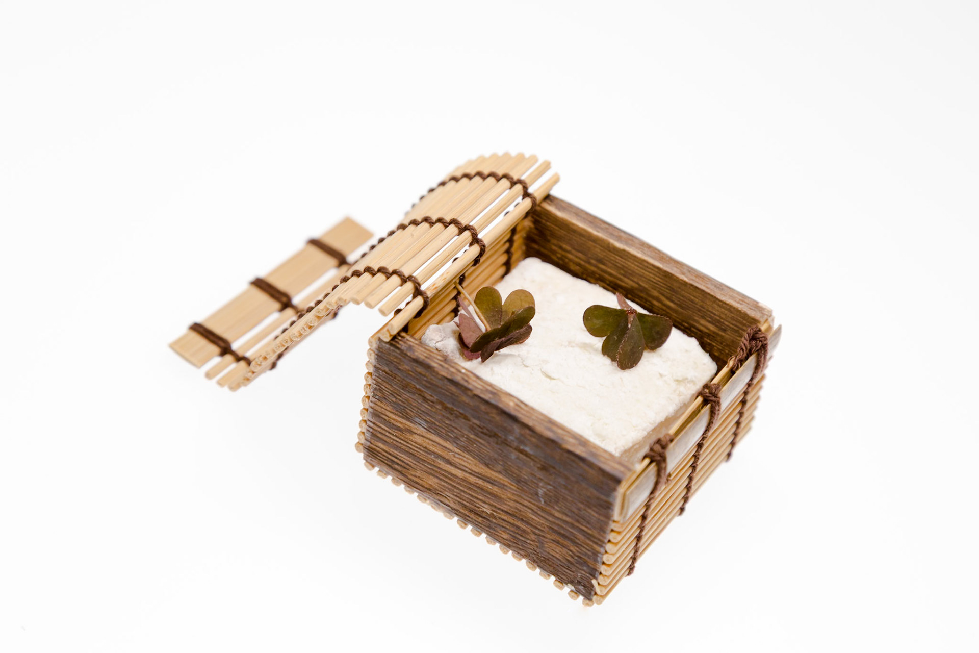 Fog Lark, Portland, Oregon - April 6th 2018: A small wooden box with a lid open, containing a white substance and two small green leaves.