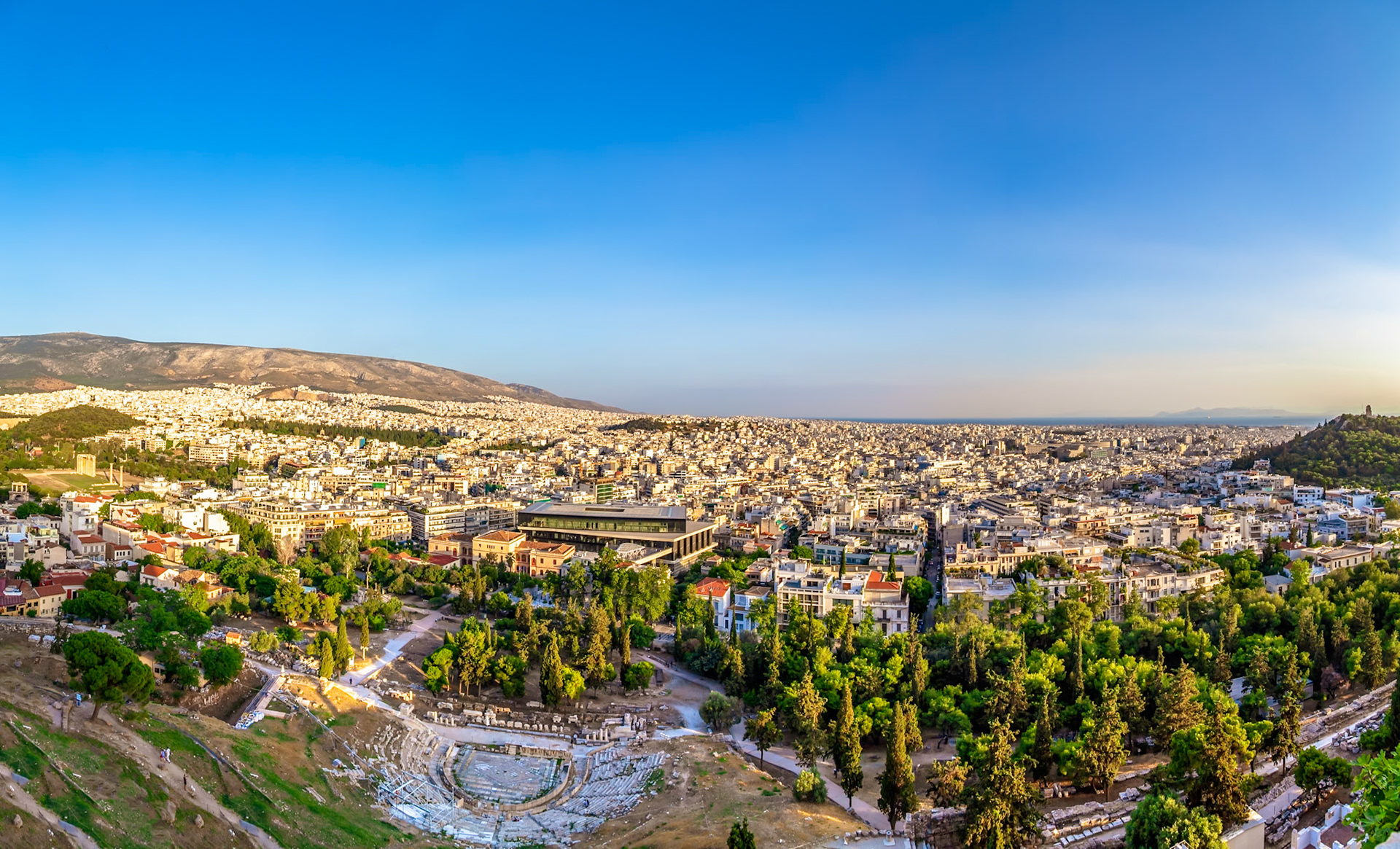Acropolis, Athens, Greece - May 23rd 2018: A panoramic view captures the city, showcasing the ancient Theatre of Dionysus and the vast urban sprawl.