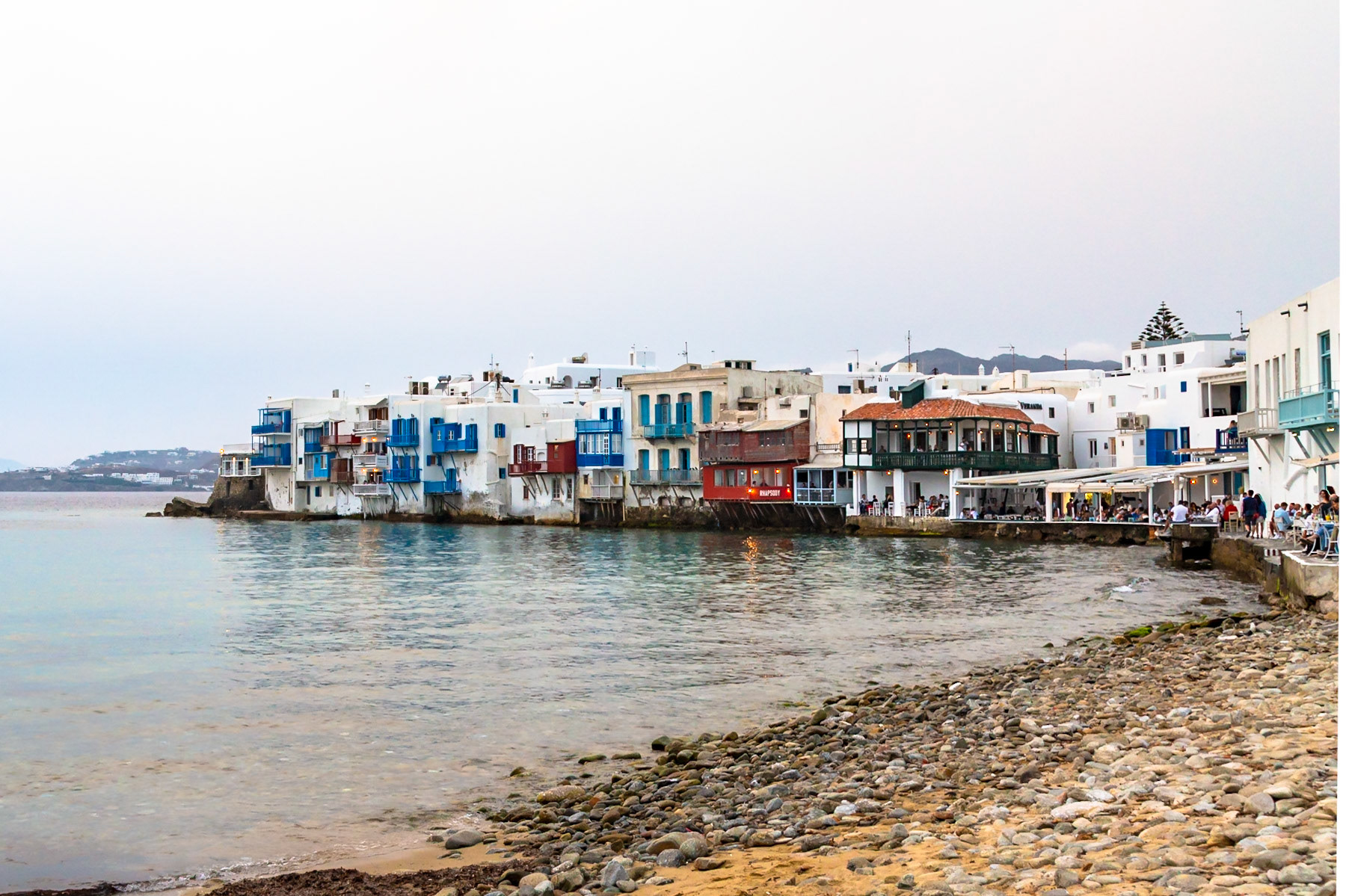 Mykonos, Greece - May 23rd 2018: People dine at waterfront restaurants in Little Venice, enjoying the views and ambiance of the iconic location.