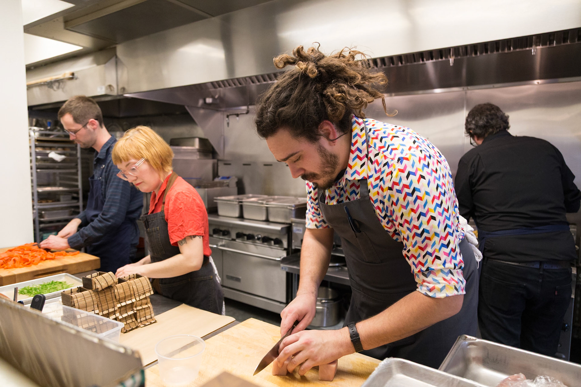 Fog Lark, Portland, Oregon - April 6th 2018: Chefs prep ingredients in a professional kitchen, slicing vegetables and preparing food for service.