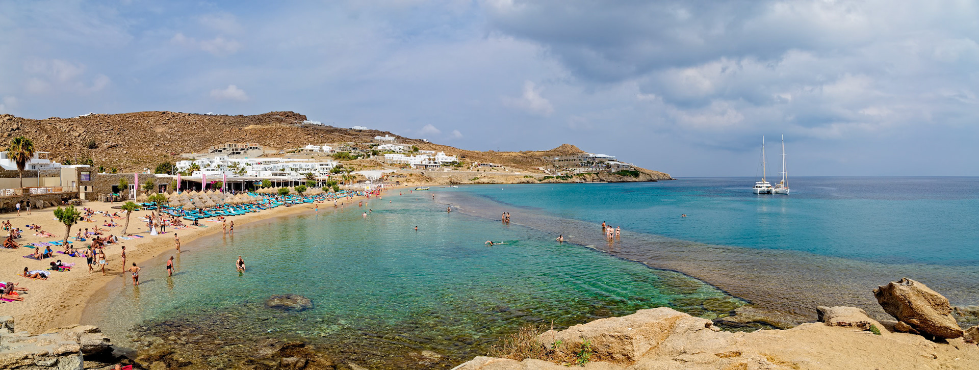 Paradise Beach, Mykonos, Greece - May 24th 2018: People enjoy swimming and sunbathing on a sunny day at the popular beach destination.