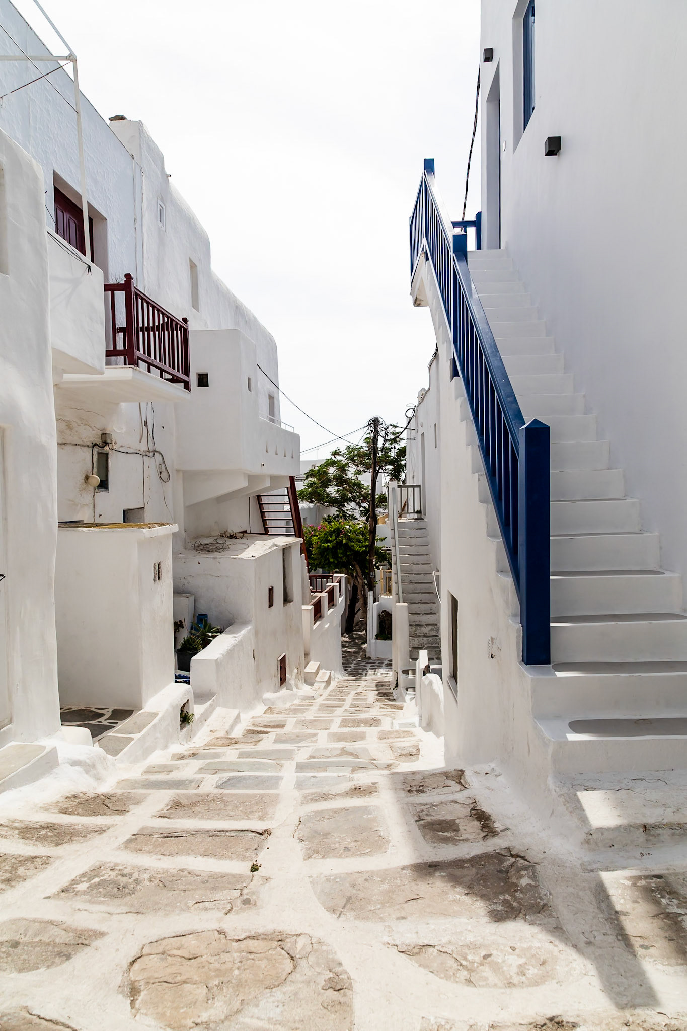 Mykonos, Greece - May 22nd 2018: A narrow, stepped street lined with white buildings and blue accents, showcasing the island's unique architecture.
