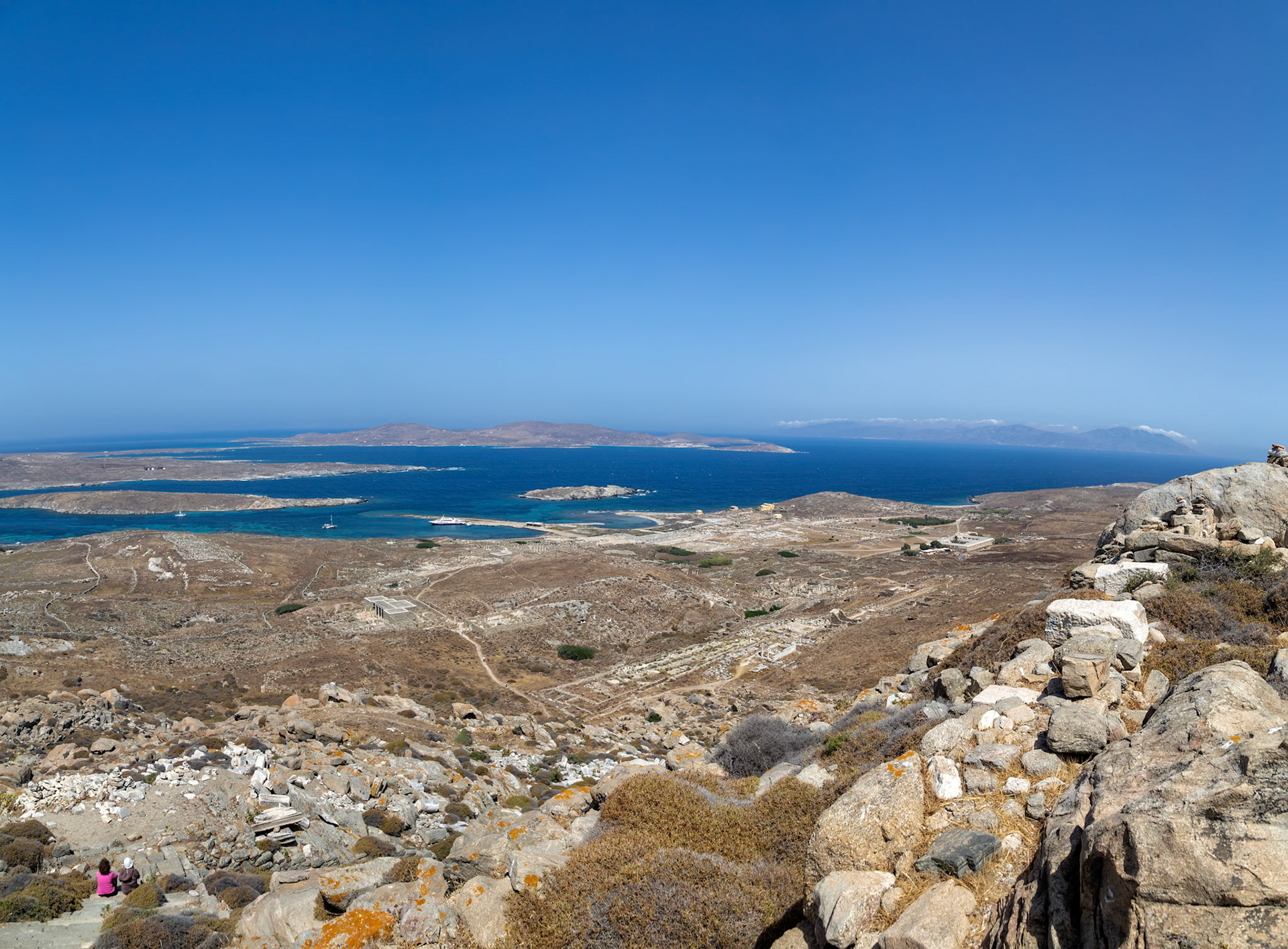 Delos, Greece - May 22nd 2018: Tourists explore the ancient ruins of Delos, a UNESCO World Heritage site, to learn about Greek history and culture.