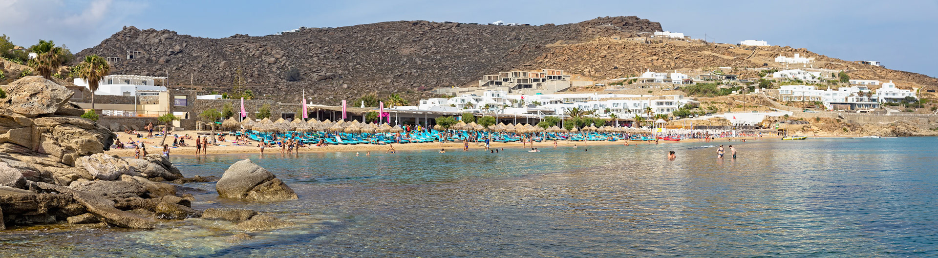 Paradise Beach, Mykonos, Greece - May 24th 2018: People are enjoying the sun and swimming in the sea at the popular beach resort.
