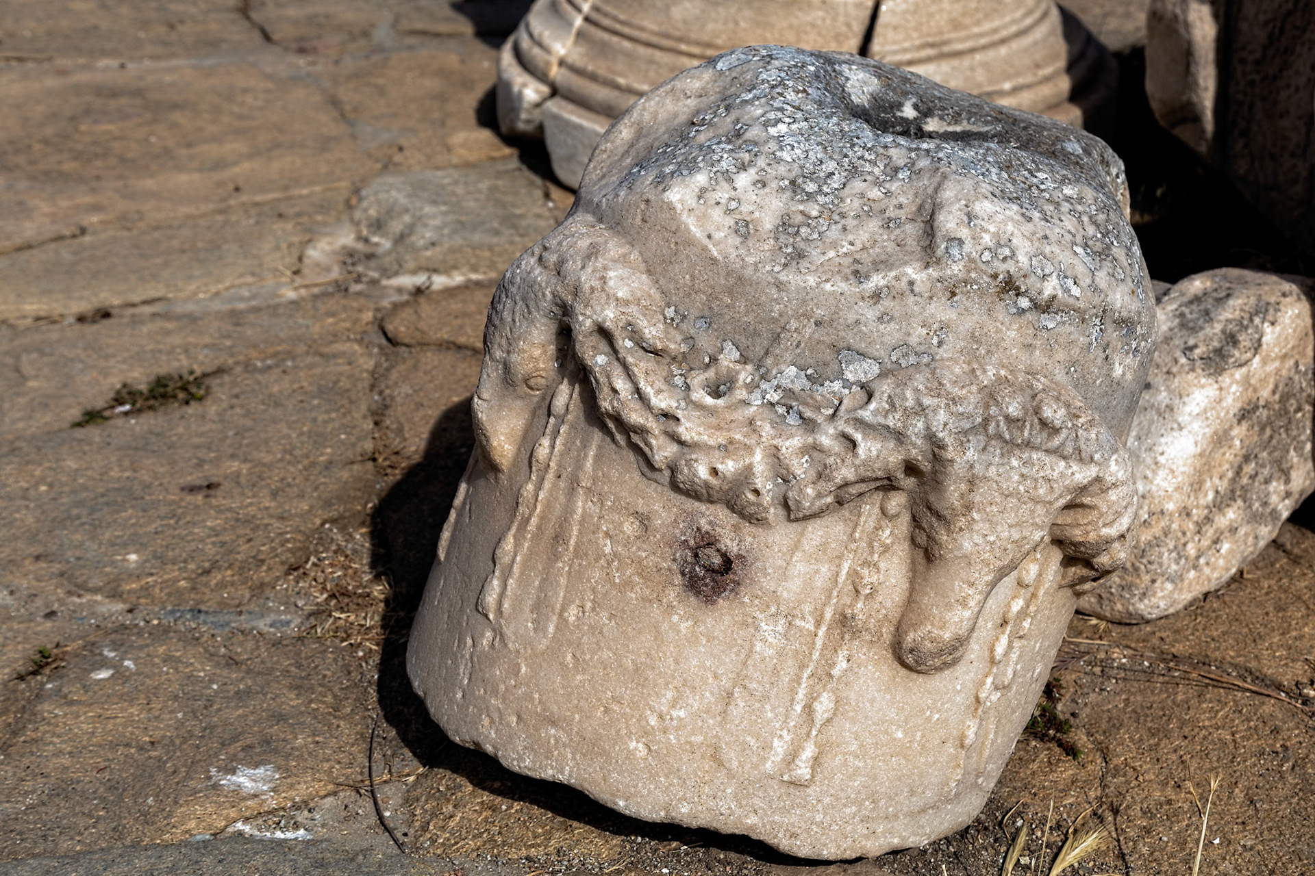 Delos, Greece - May 22nd 2018: A weathered marble sculpture fragment rests on ancient stone, showcasing the island's rich archaeological heritage.