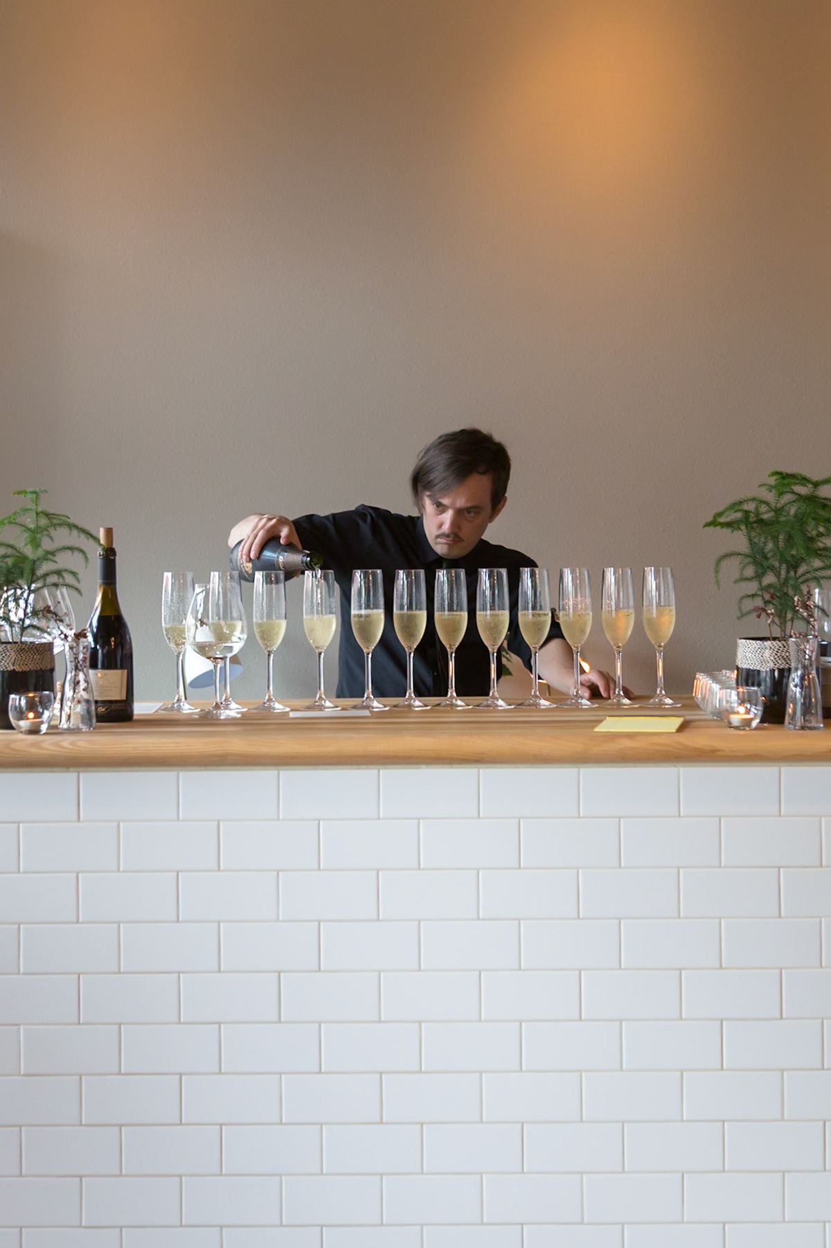 Fog Lark, Portland, Oregon - April 6th 2018: A bartender pours champagne into glasses for a tasting, ensuring each is perfectly filled.