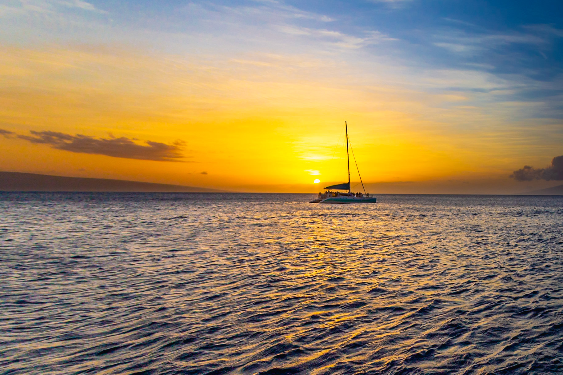 Maui, Hawaii, USA - April 7th 2022: A sailboat with tourists enjoys a sunset cruise off the coast of Maui, taking in the beautiful scenery.