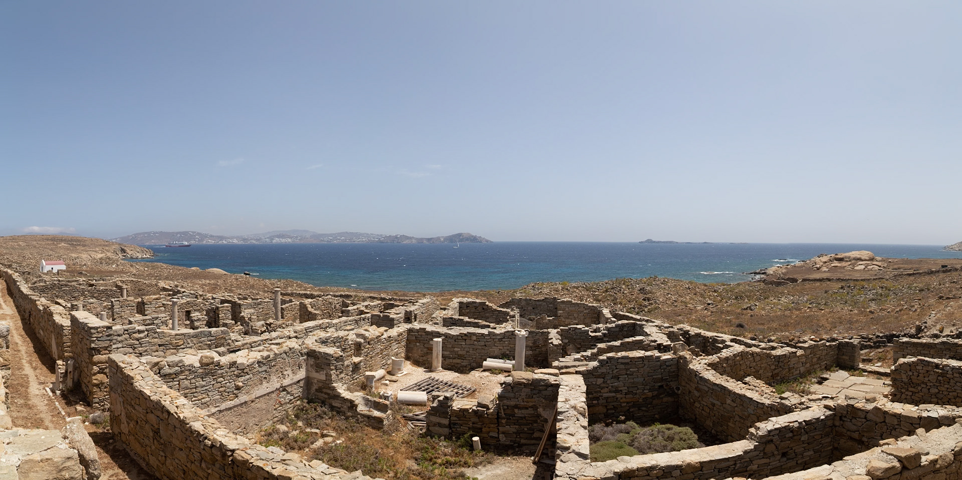 Delos, Greece - May 22nd 2018: An aerial view of the House of the Dolphins ruins, showcasing the ancient architecture and coastal landscape of Delos.