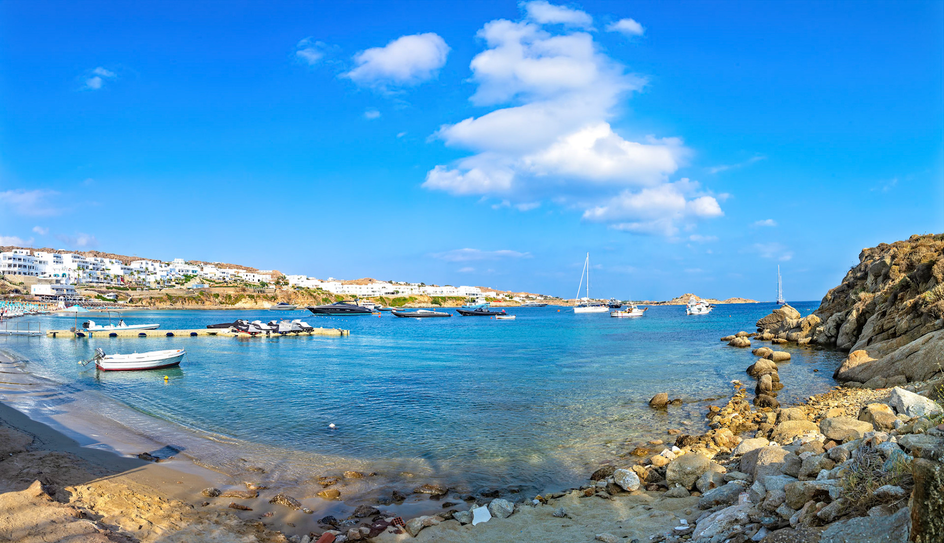Psarou Beach, Mykonos, Greece - May 24th 2018: Yachts and boats dot the turquoise waters of Psarou Beach, a popular destination for luxury travel.