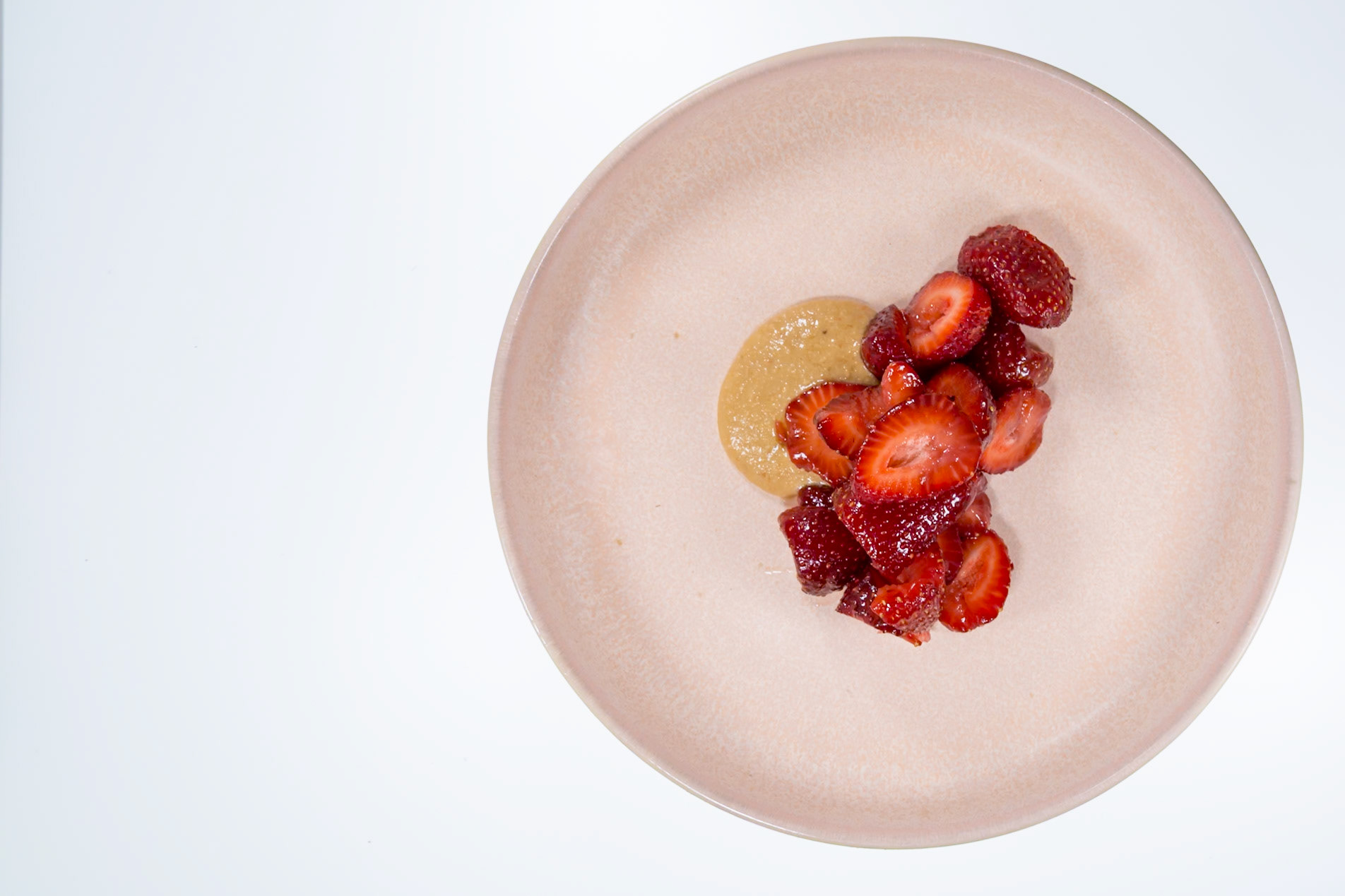Fog Lark, Portland, Oregon - April 6th 2018: A plate with sliced strawberries and a sauce, likely a dessert course.