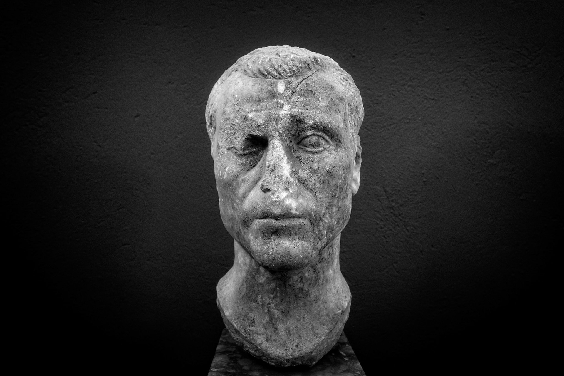 Delos, Greece - May 22nd 2018: A weathered marble bust of a man, possibly a Roman official, stands as a testament to the island's rich history and cultural significance.