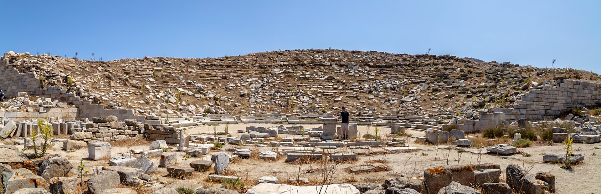 Delos, Greece - May 22nd 2018: A tourist explores the ancient Theatre of Delos, a historical site showcasing Greek architecture and cultural heritage.