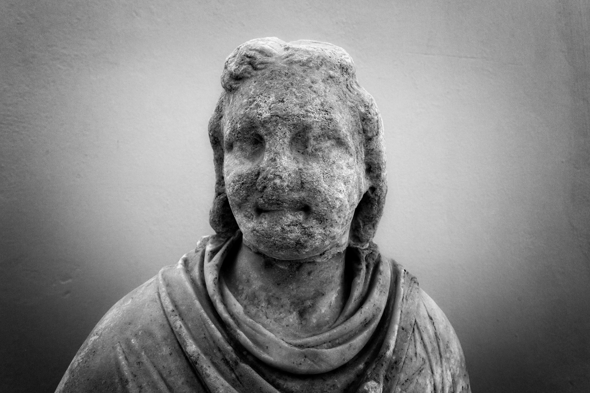 Delos, Greece - May 22nd 2018: A weathered statue of a person draped in cloth stands as a testament to the island's rich history and artistic heritage.