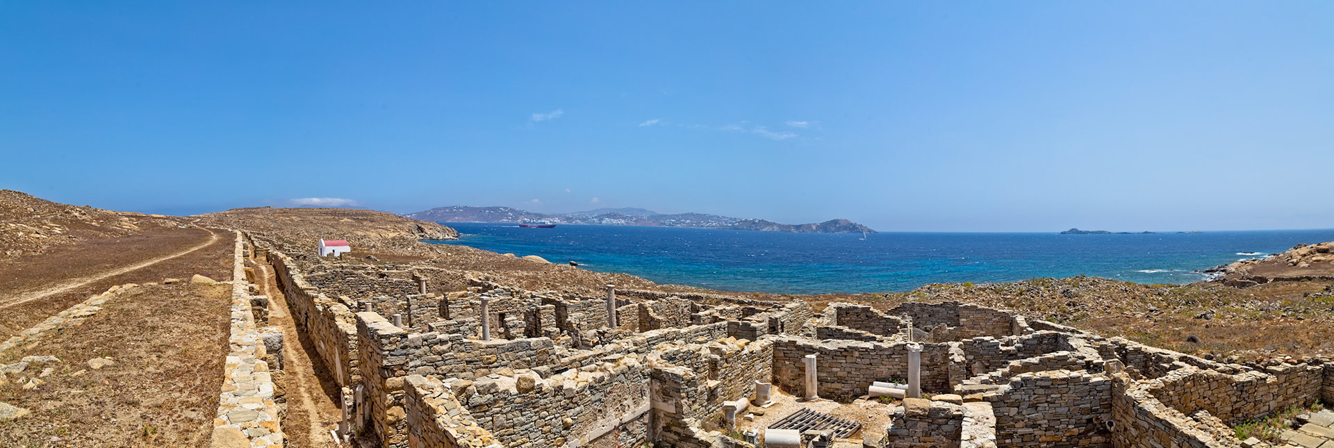 Delos, Greece - May 22nd 2018: Ruins of ancient buildings stand on the island, showcasing the historical significance and architectural heritage of the site.