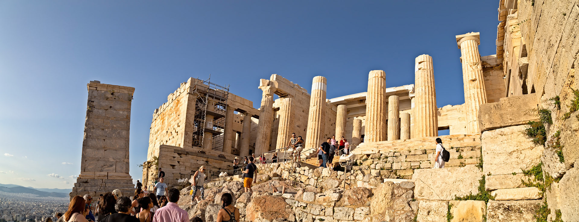 Acropolis, Athens, Greece - May 23rd 2018: Tourists explore the ancient ruins of the Acropolis, ascending the stone steps to view the historic architecture.