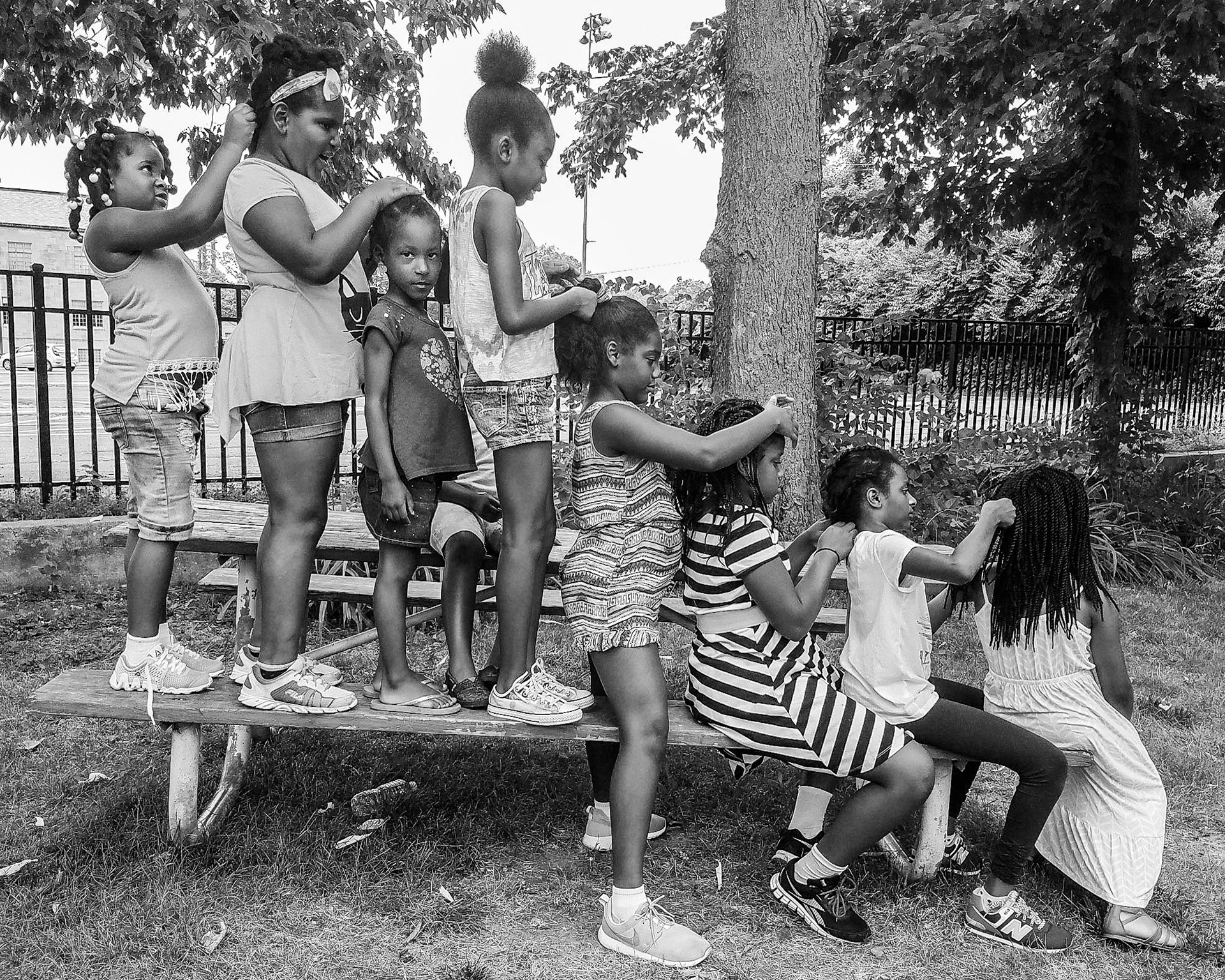 Students of Building Blocks Academy work on each others hair during recess and dub it "The Hair Train" in a park near the school in Indianapolis, July 11, 2016.