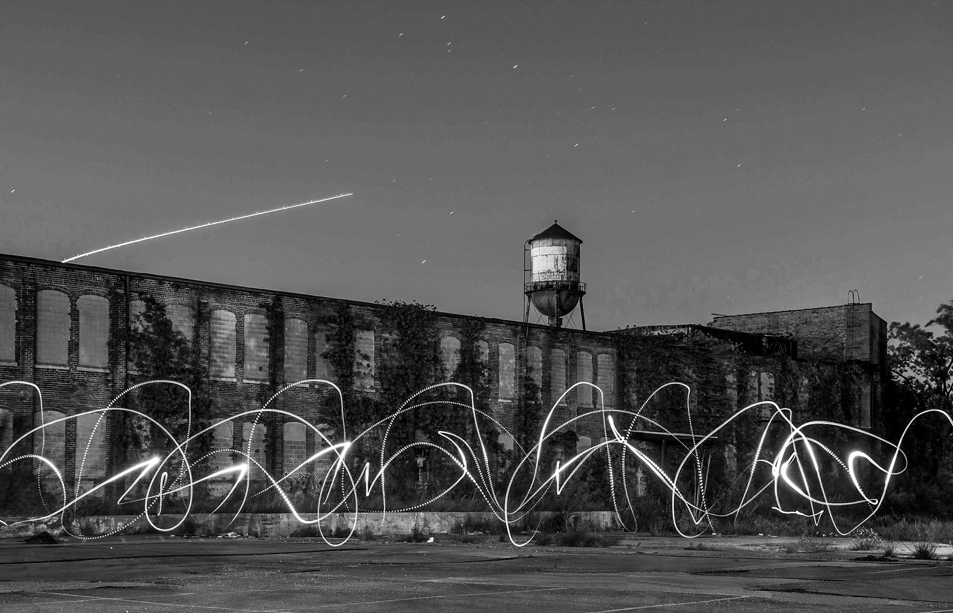 A long exposure light painting scene in front of the long-abandoned historic National Motor Vehicle Co. factory on the Northside of Indianapolis, May 13, 2017. The large brick factory produced some of the earliest cars in Indiana between 1900 and 1924, originally electric vehicles then transitioning to gas vehicles, but has been neglected for decades.