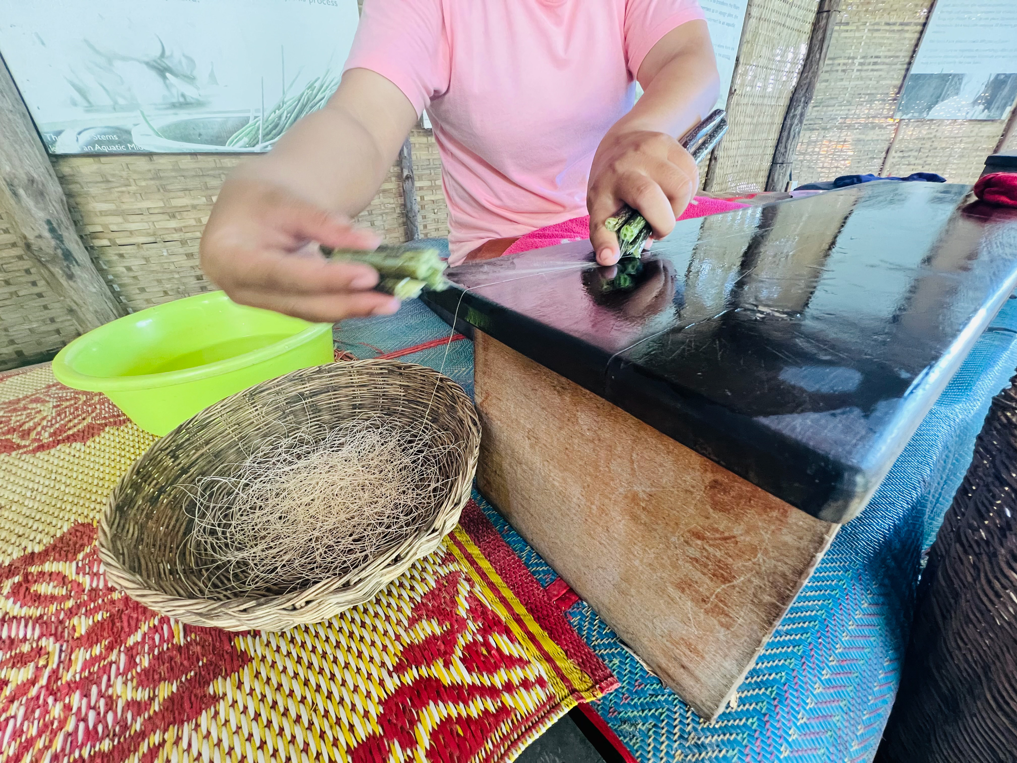 Turning the lotus fibres from the stem into thread.