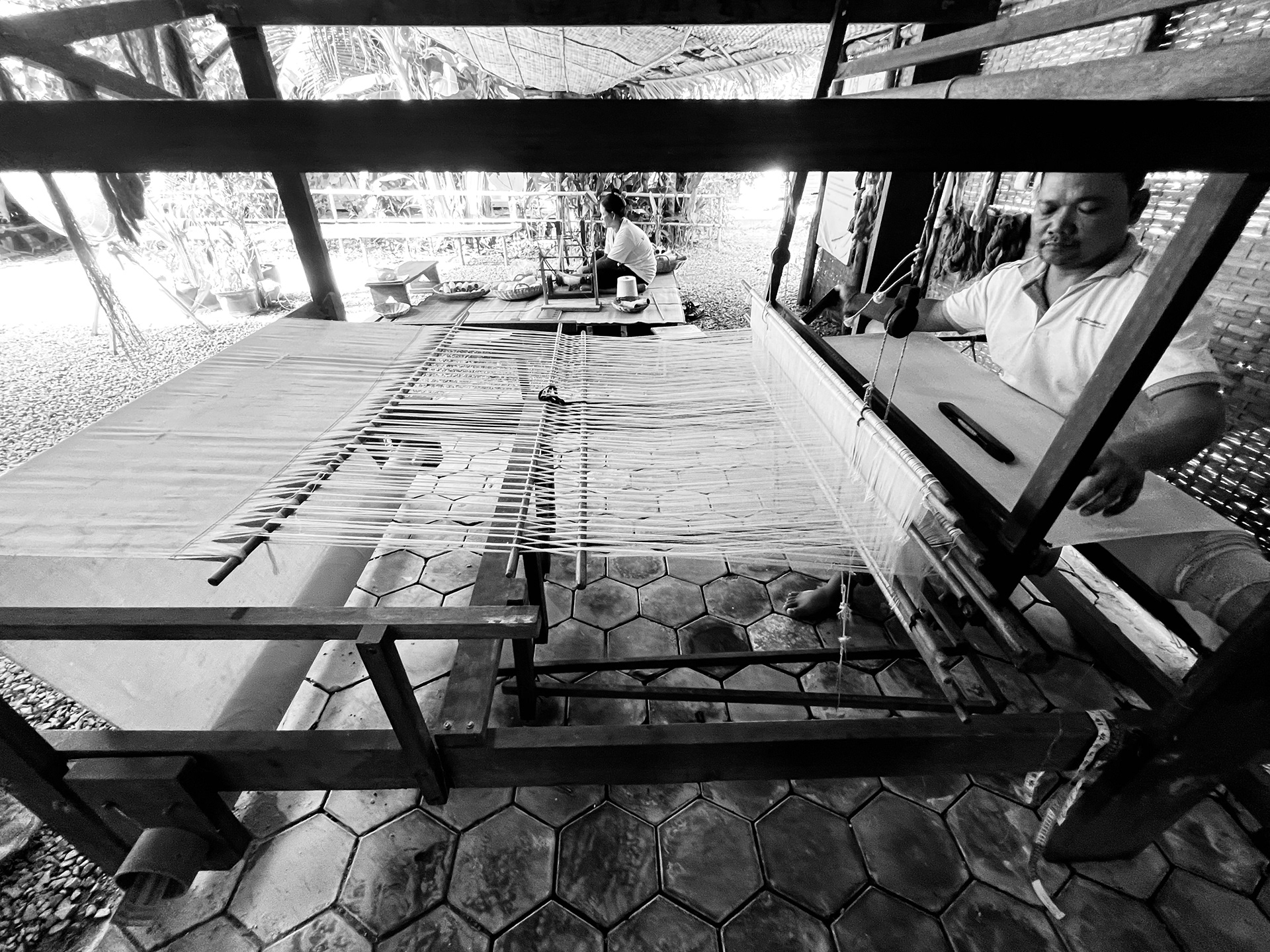 Hand weaving the thread into fabric.