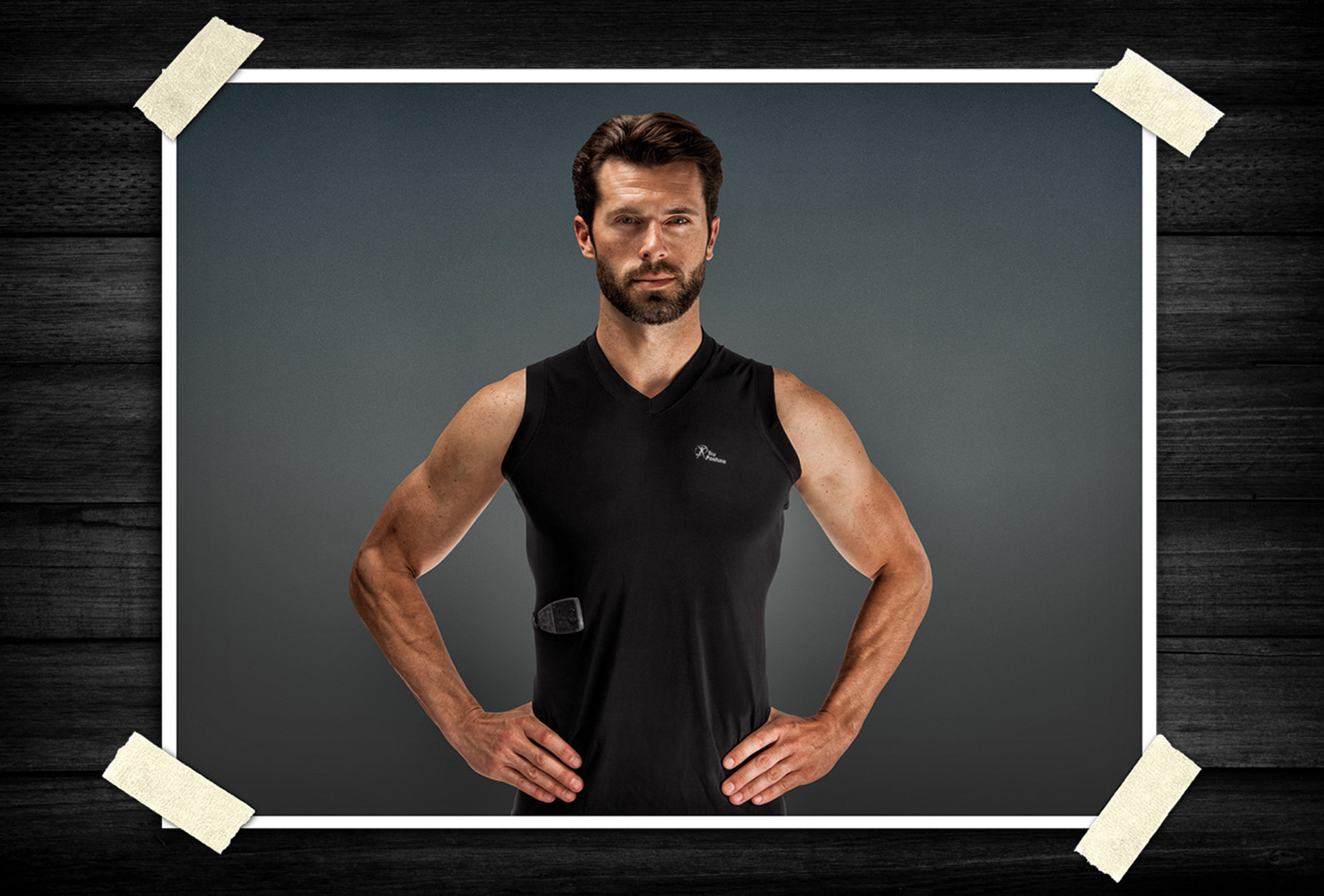 Athletic male model wearing a black performance compression shirt in a studio setting, showcasing activewear design and fitness apparel.