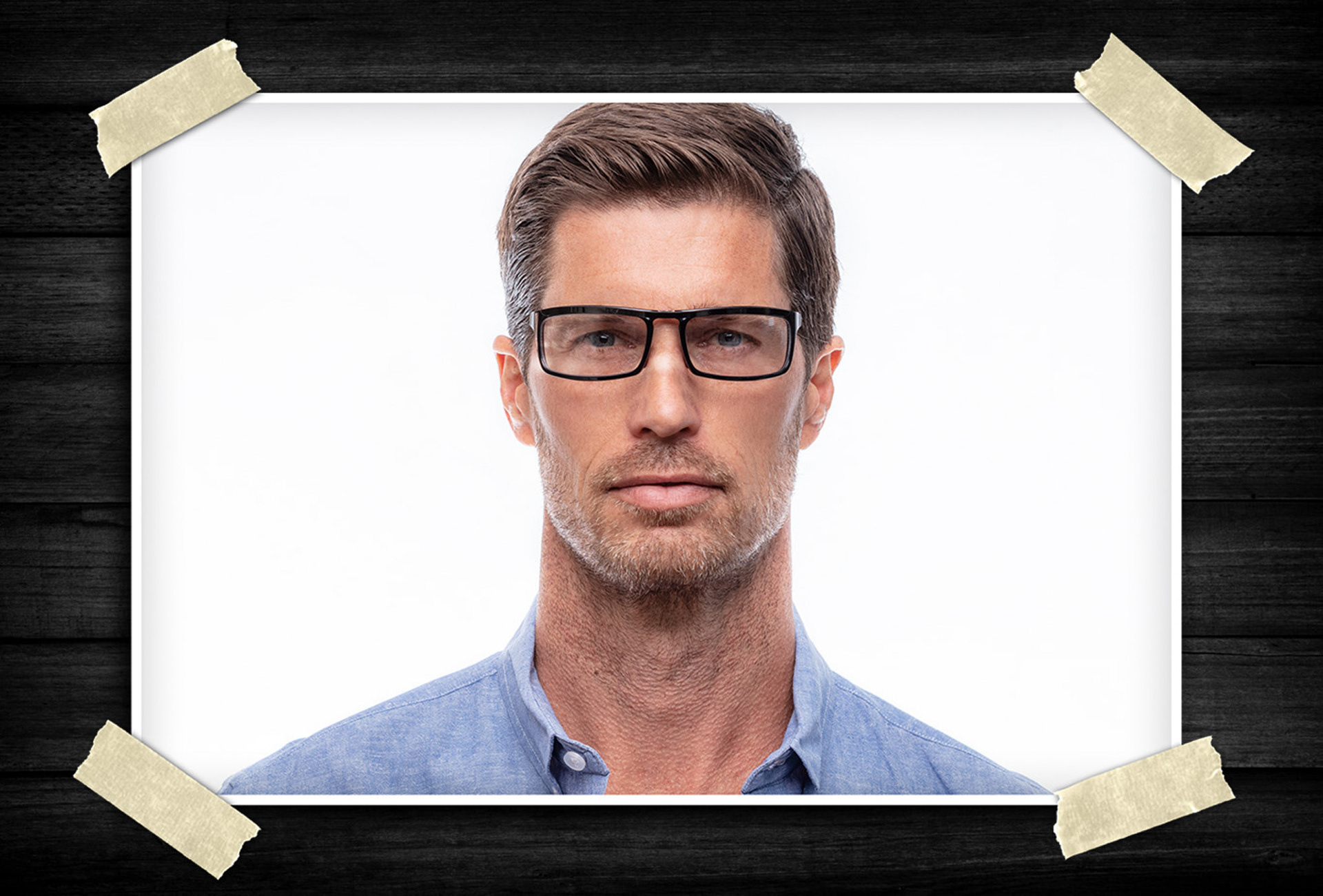 Close-up portrait of a male model wearing black rectangular eyeglasses against a clean studio background, highlighting modern eyewear design.