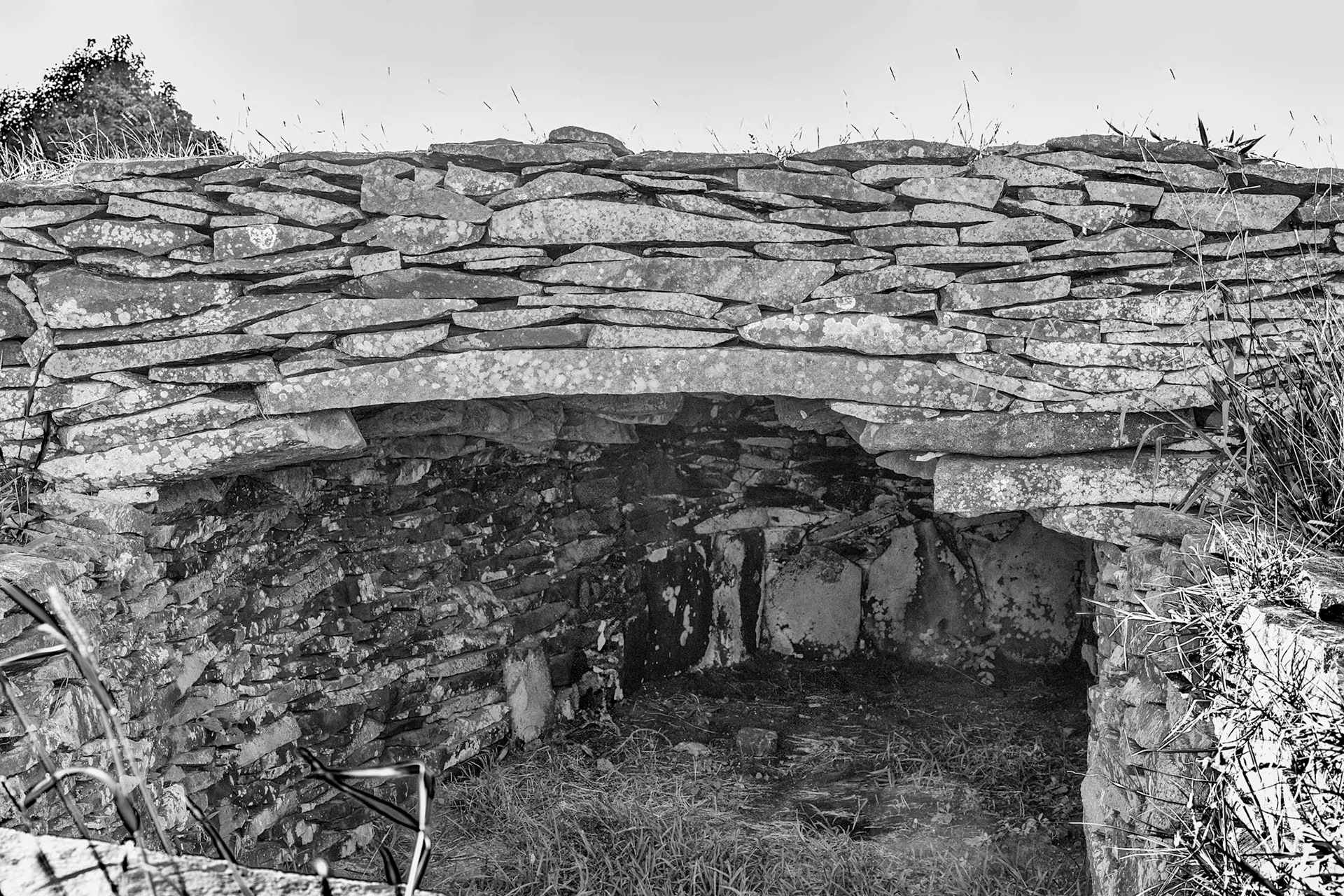 A portion of one sod covered roof removed to show the cantilevered stacked stone construction living areas.